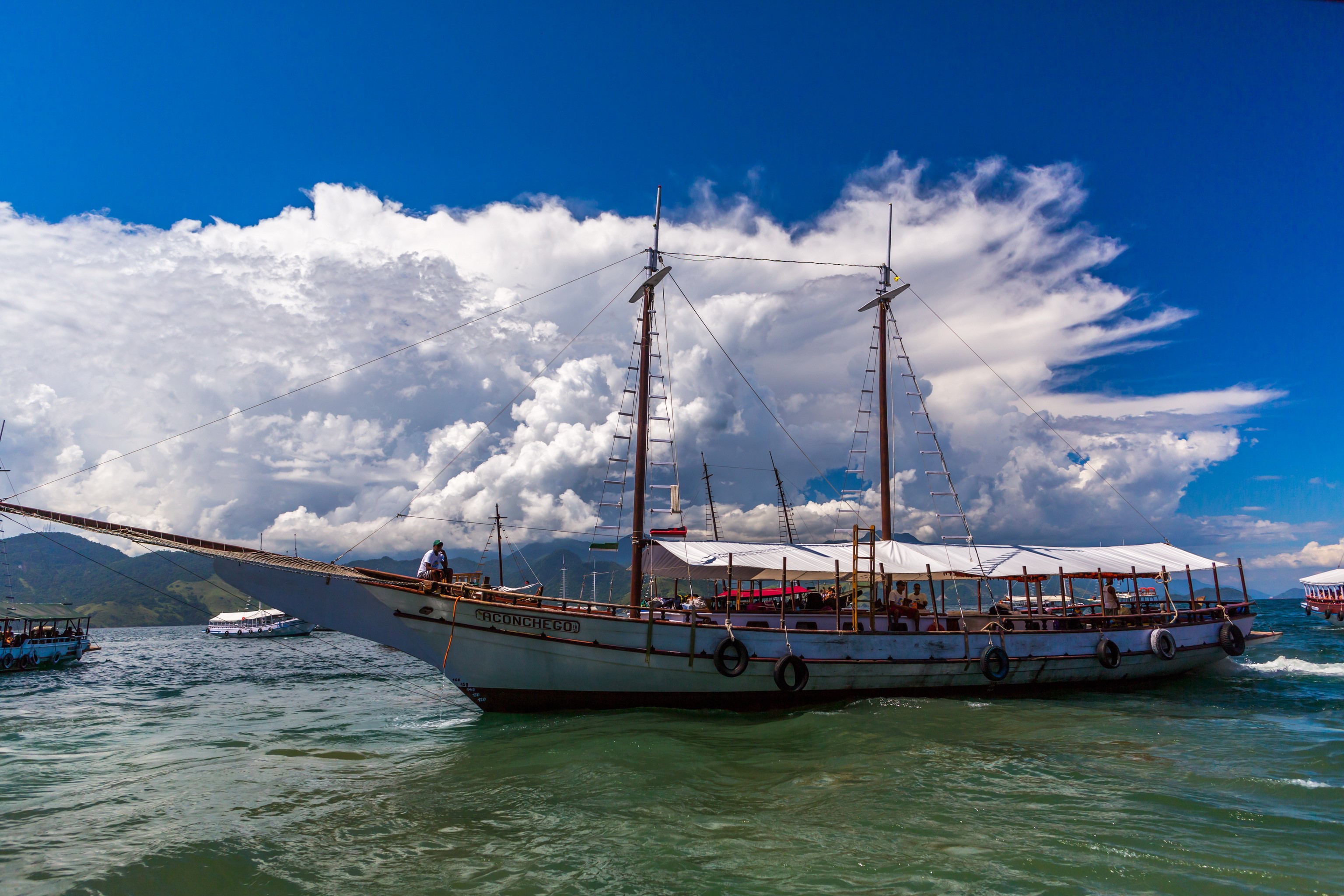 Sailboat with people on the water under clouds HD Wallpaper