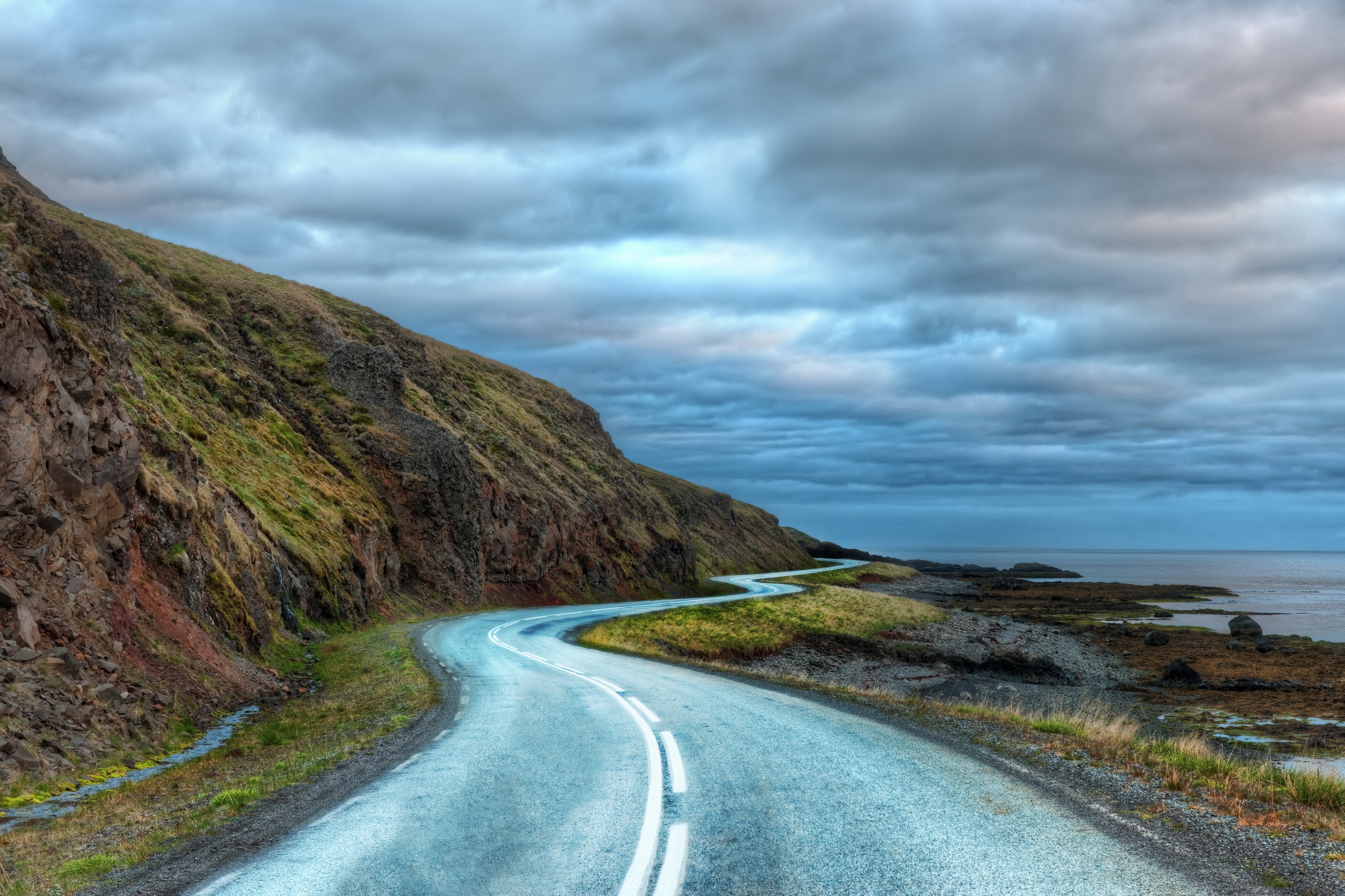 Winding Road by the Sea Under Cloudy Sky HD Wallpaper