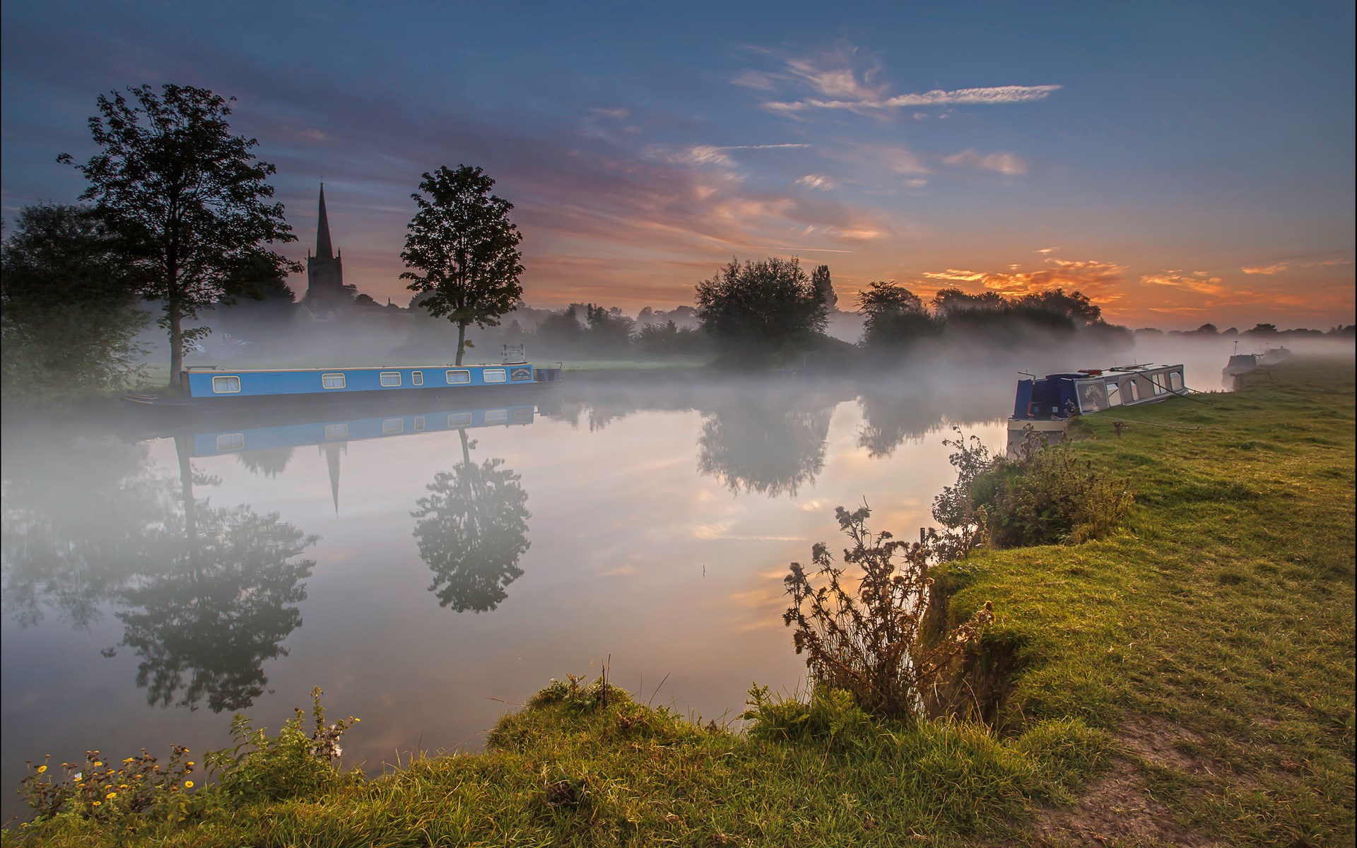 Canal boats on a misty river at sunrise with church spire HD Wallpaper