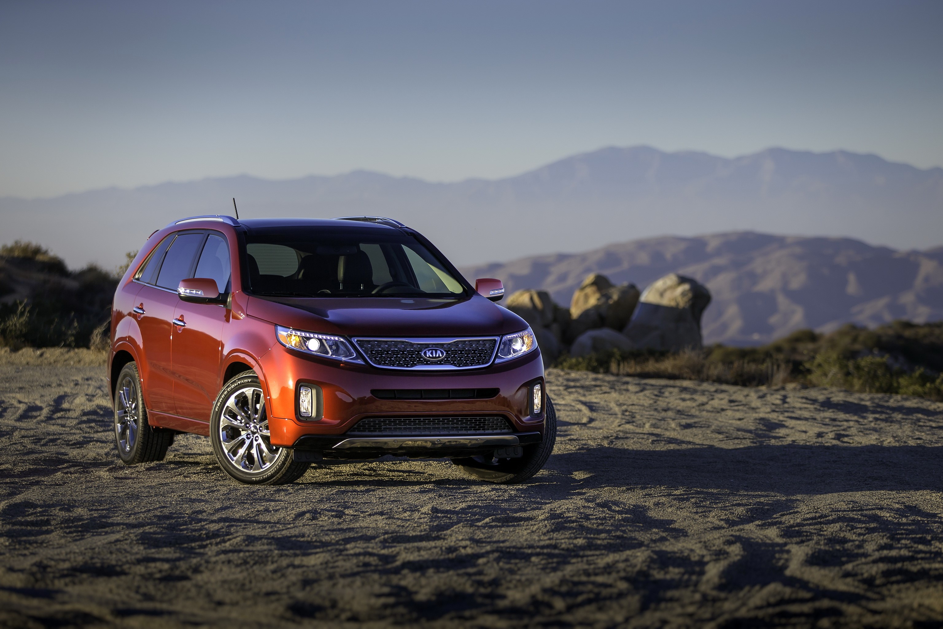2014 Kia Sorento parked on sand with mountains in background HD Wallpaper