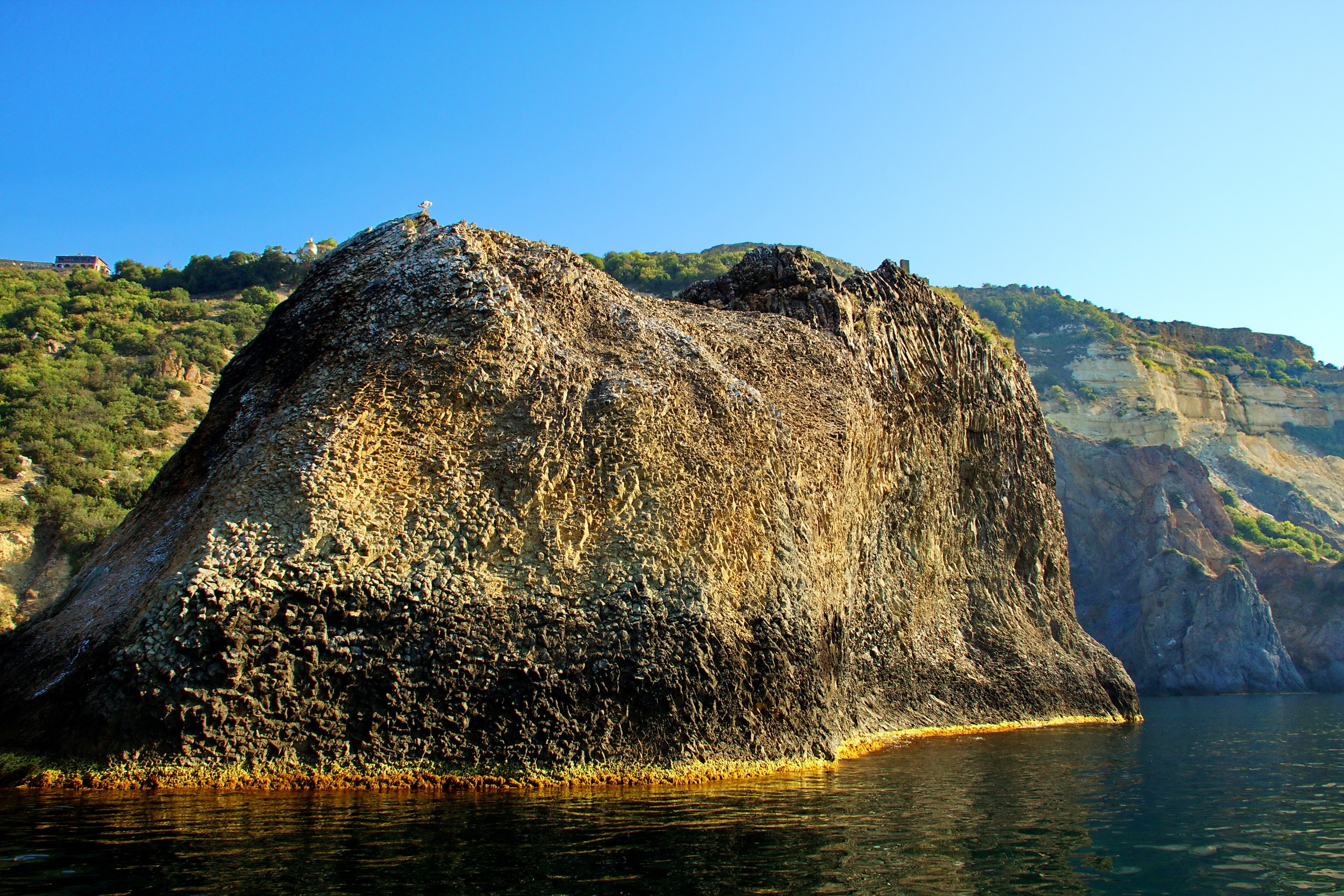 Rocky coast with cliffs and sea under a clear blue sky HD Wallpaper
