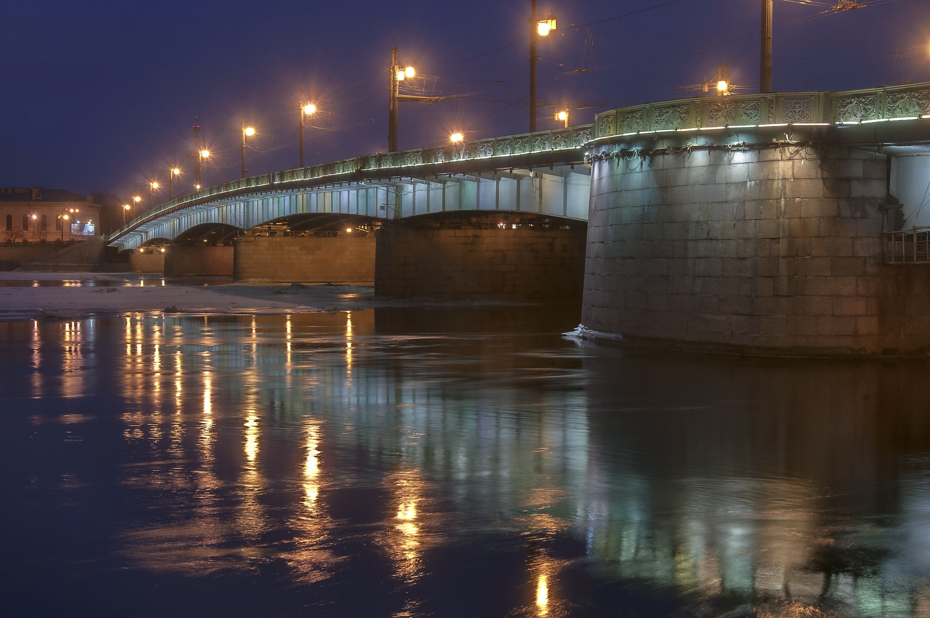 Bridge at night with street lights reflecting on water HD Wallpaper
