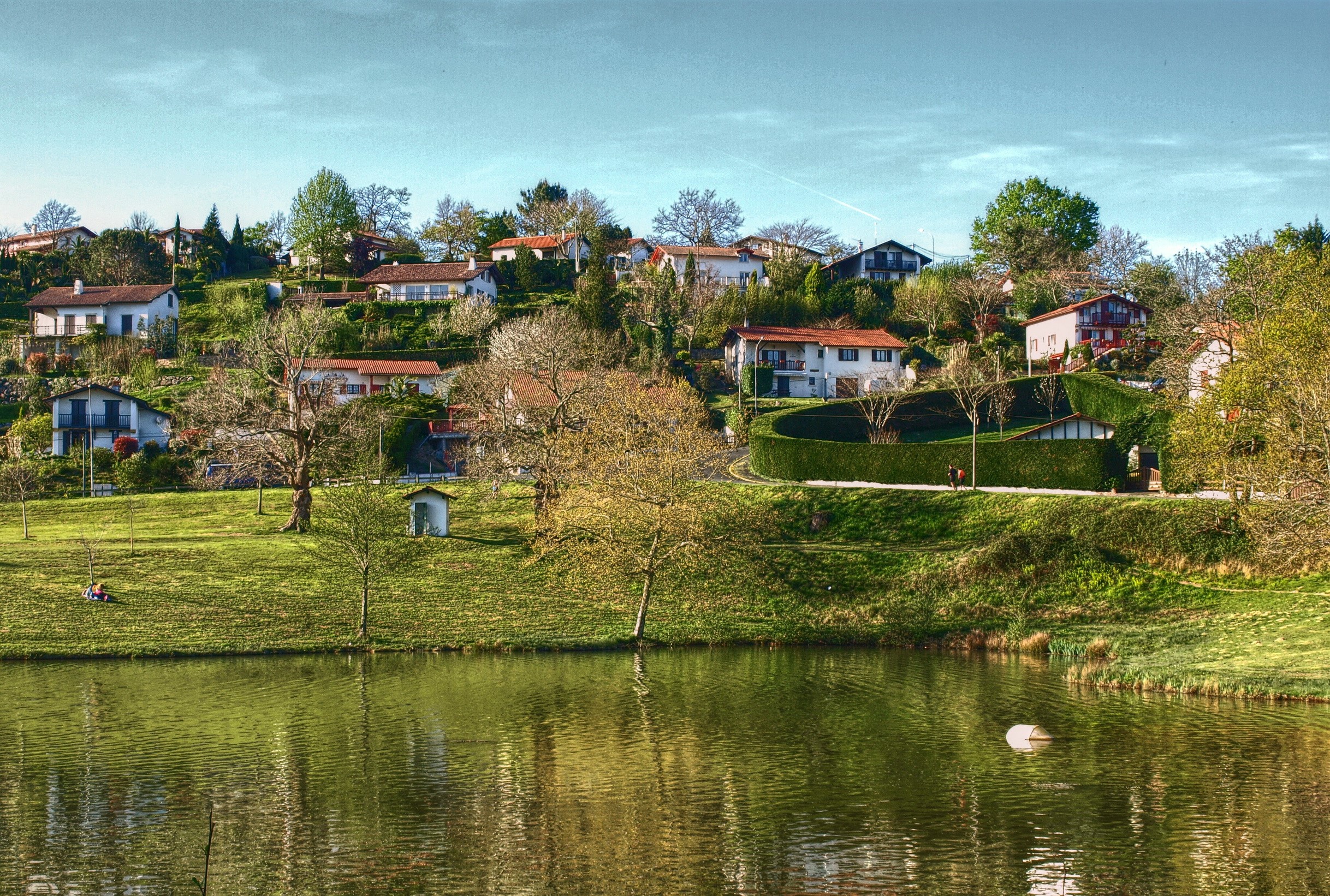 Houses on a hill overlooking a lake in Saint-Pee-sur-Nivelle, France HD Wallpaper