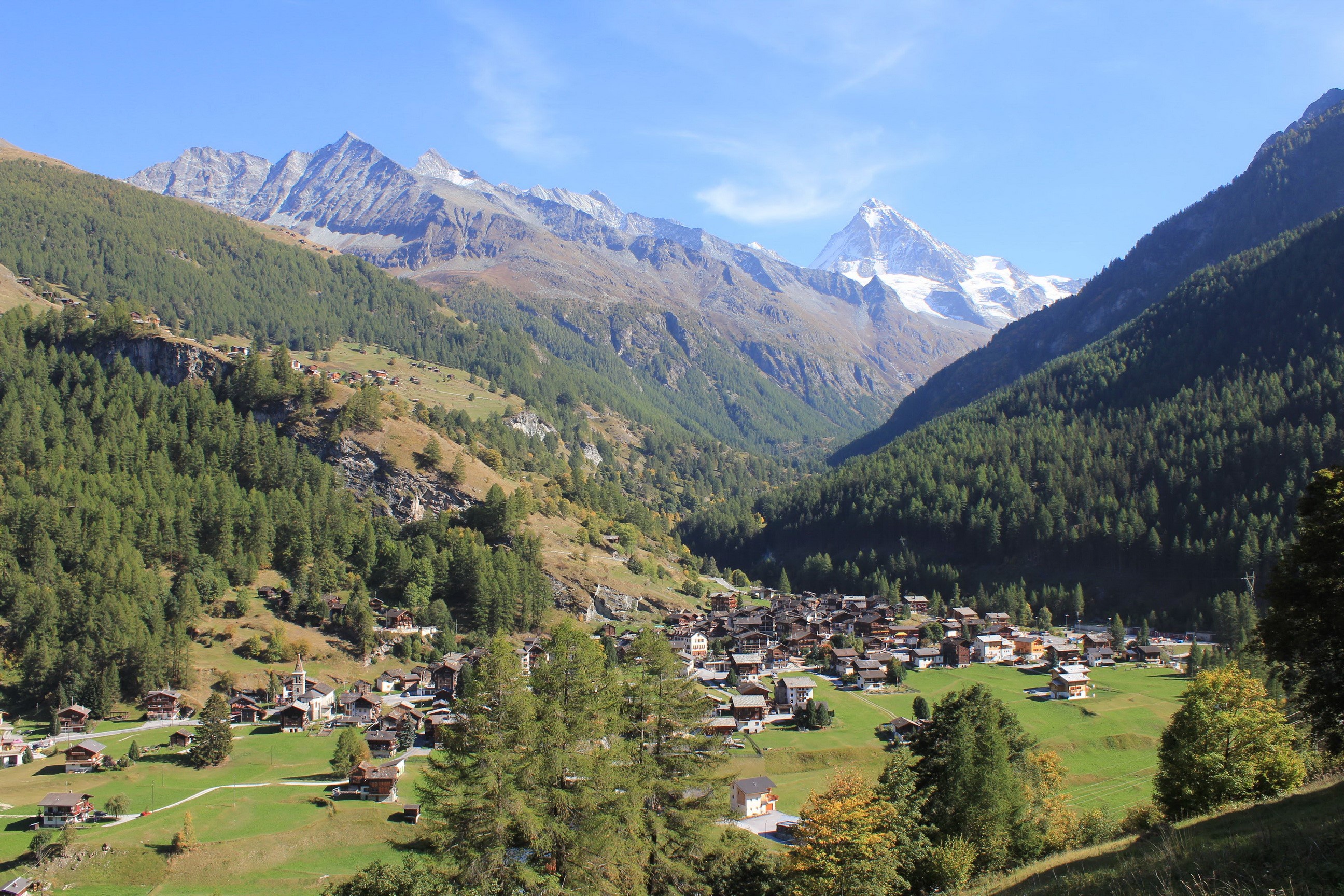 Village in a valley with snow-capped mountains in Switzerland HD Wallpaper