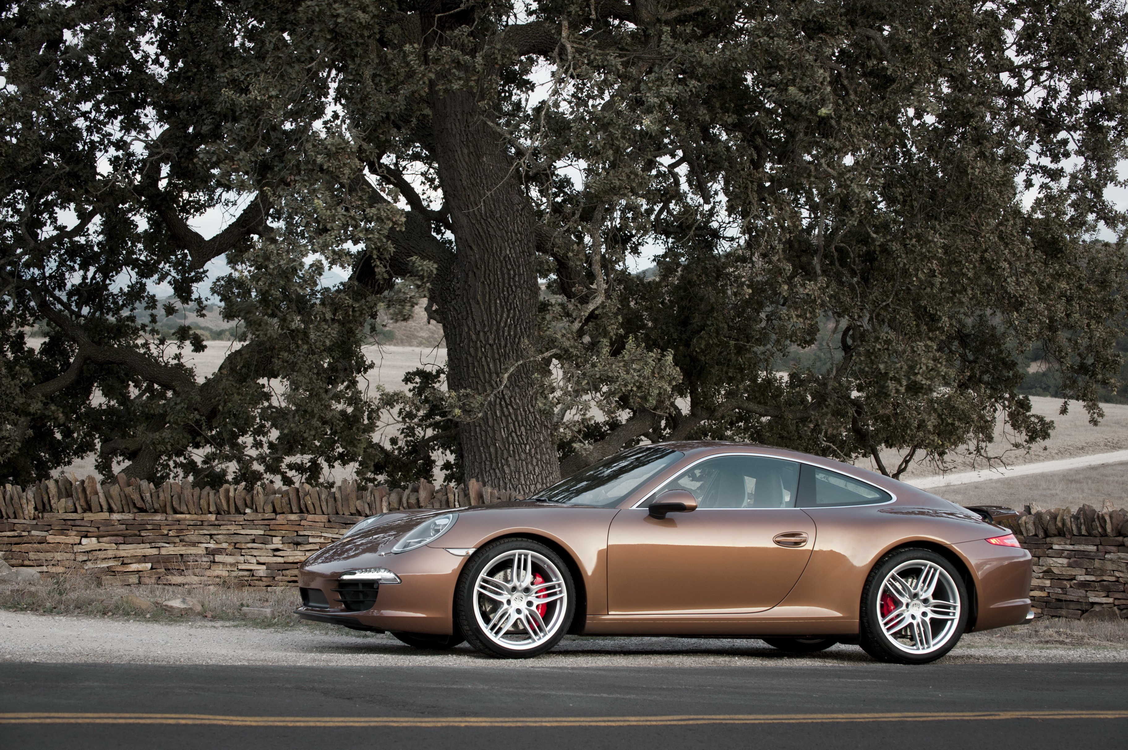 Porsche 991 Carrera S parked by a stone wall HD Wallpaper