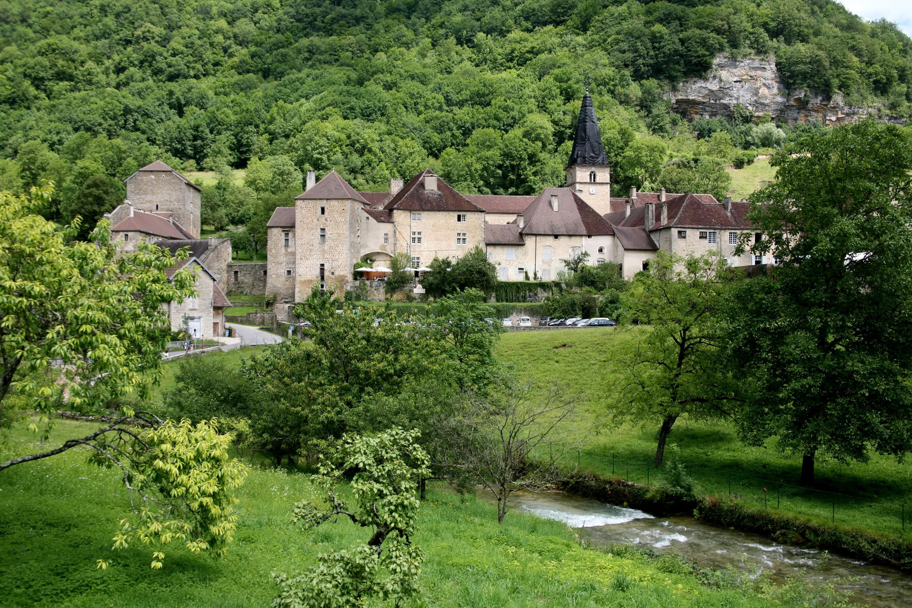 Village with church in a green valley, France HD Wallpaper