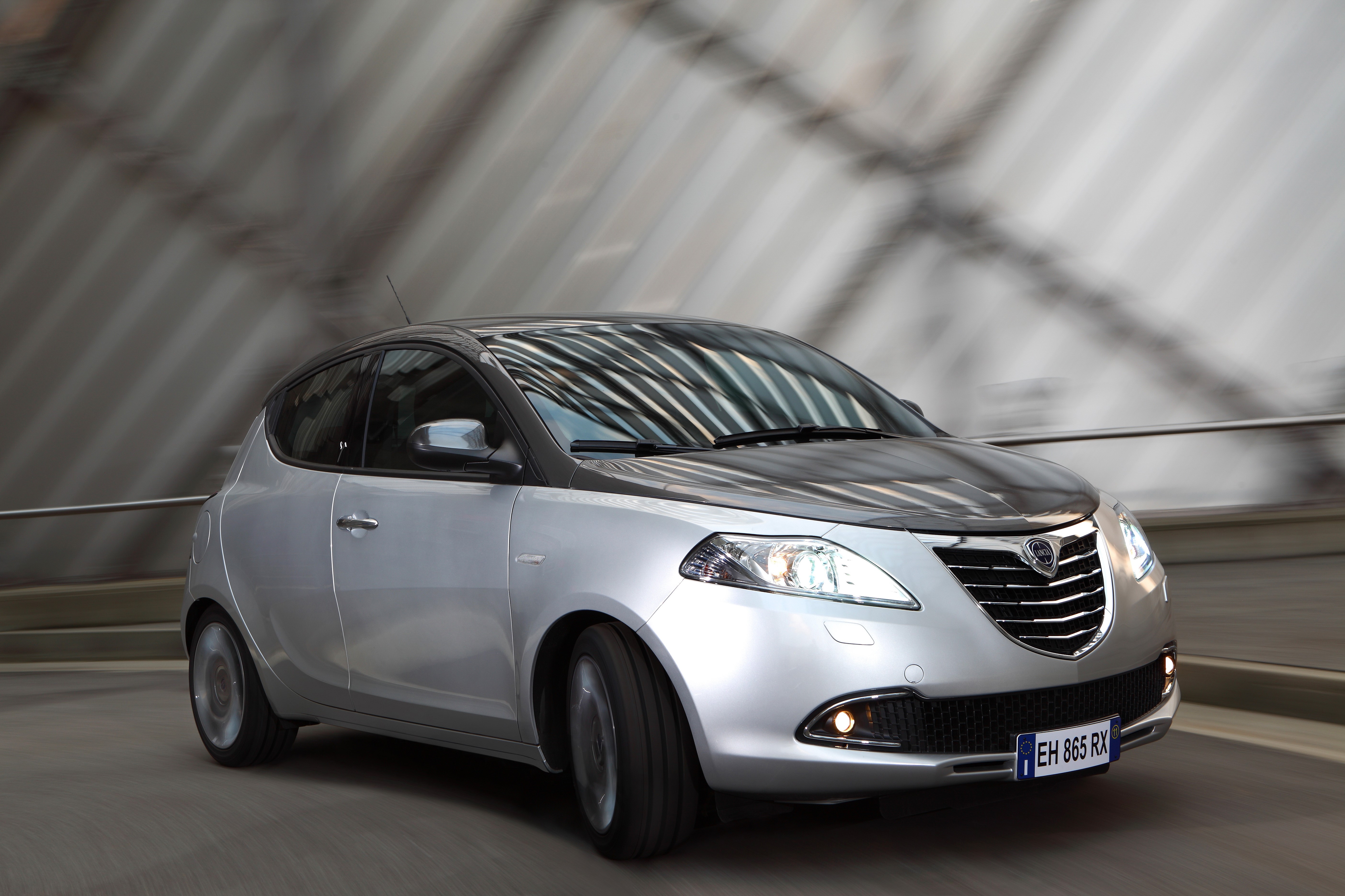 Silver Lancia Ypsilon driving on a road HD Wallpaper