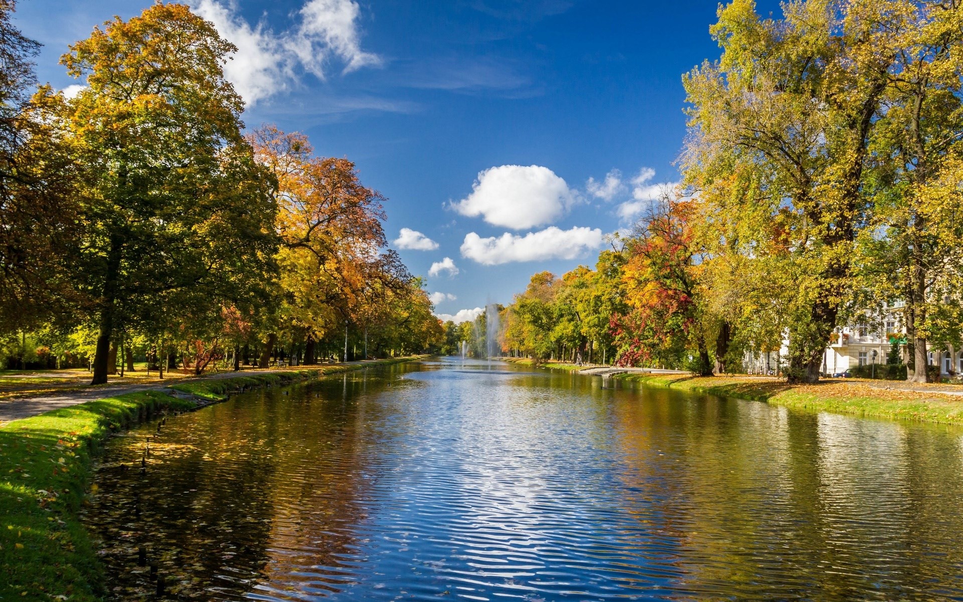 Canal with trees in autumn colors and a fountain HD Wallpaper