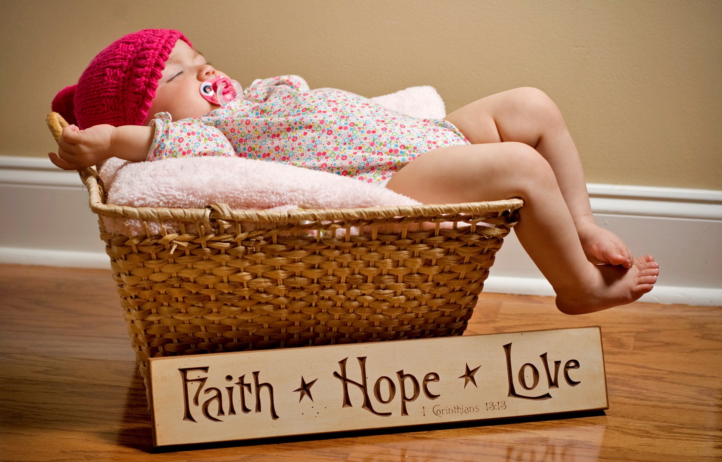 Baby sleeping in a wicker basket with a sign HD Wallpaper