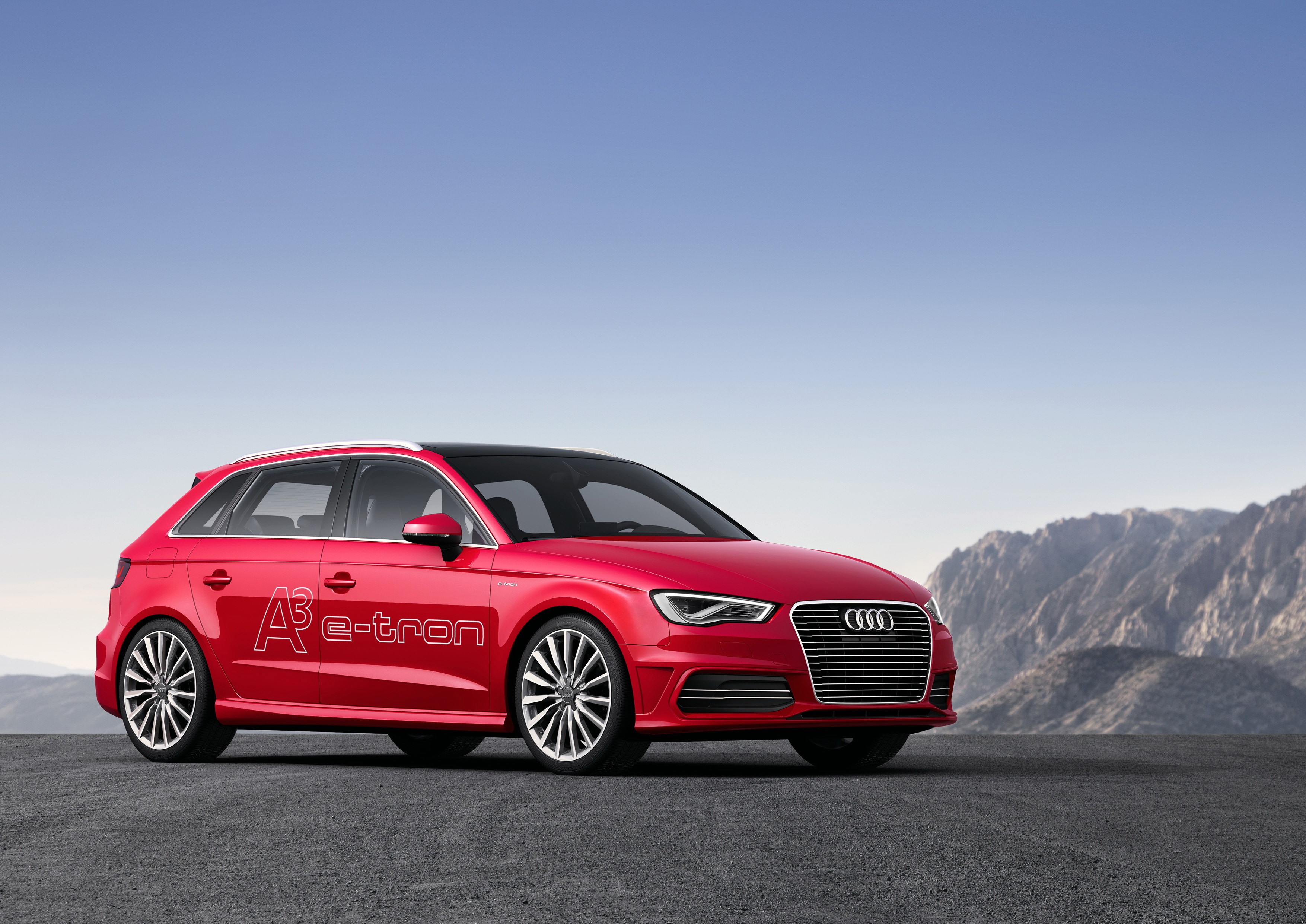 Red Audi A3 e-tron parked on asphalt with mountains in background HD Wallpaper