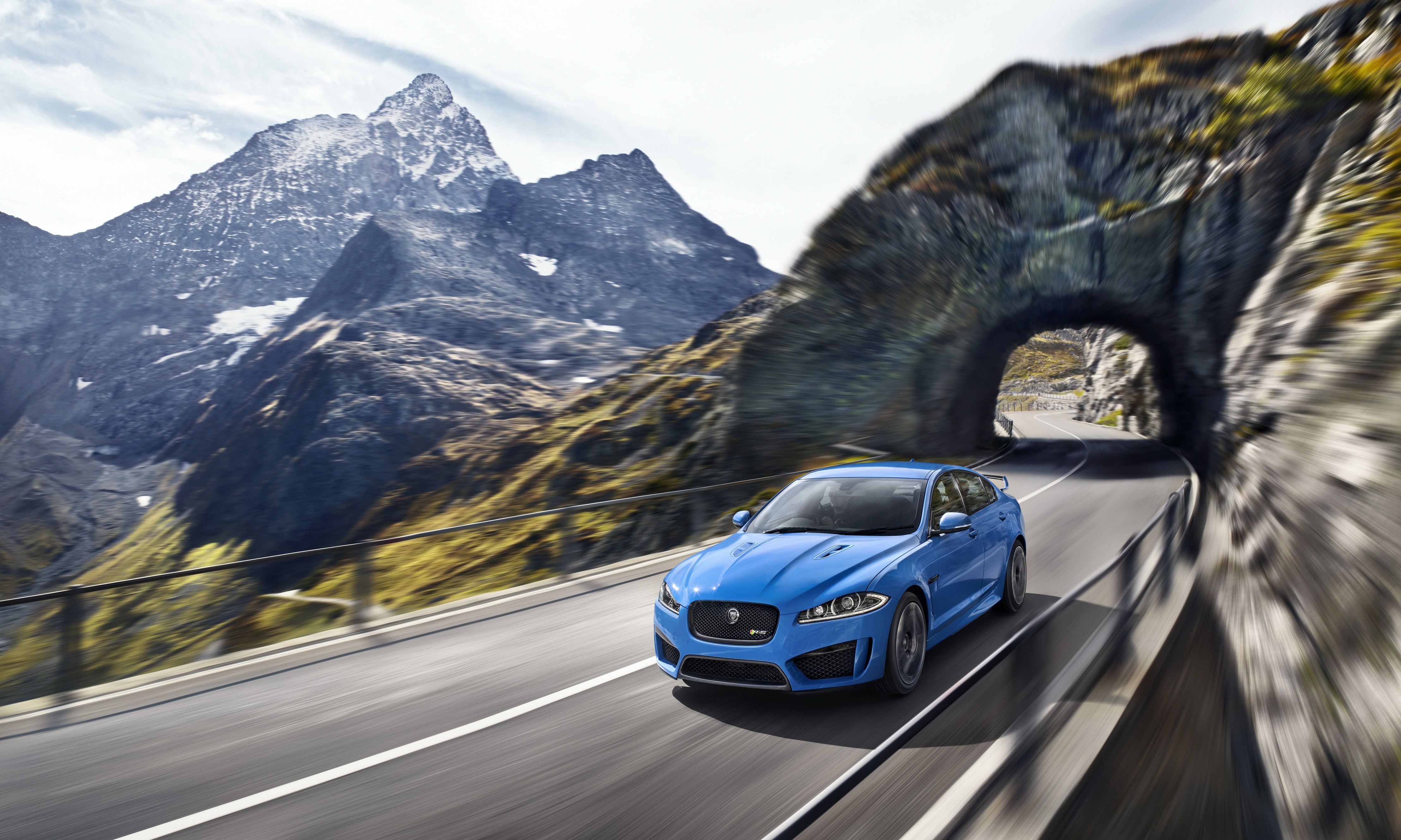 Blue Jaguar XFR-S driving through mountain tunnel HD Wallpaper