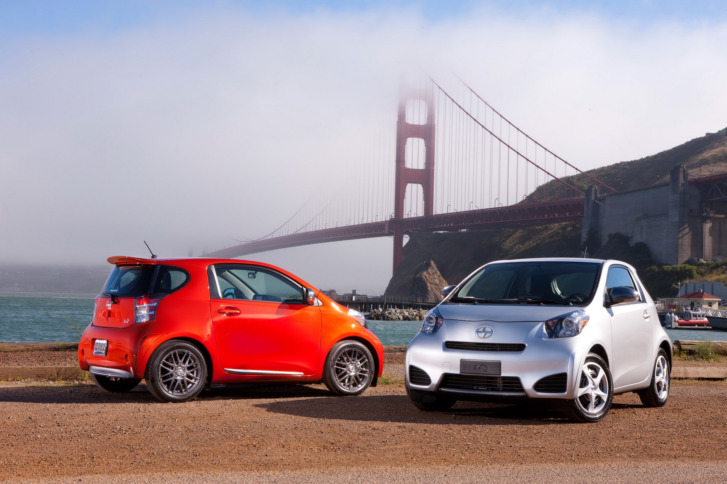 Two Scion iQ cars parked near the Golden Gate Bridge HD Wallpaper