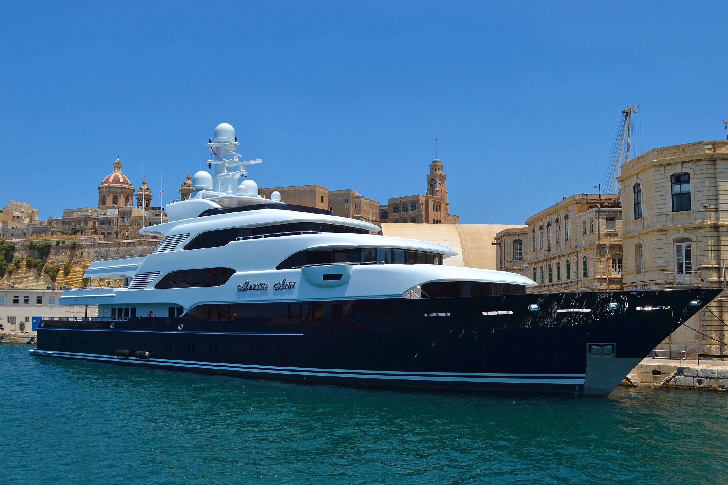 Martha Ann yacht docked in a harbor with historic buildings HD Wallpaper