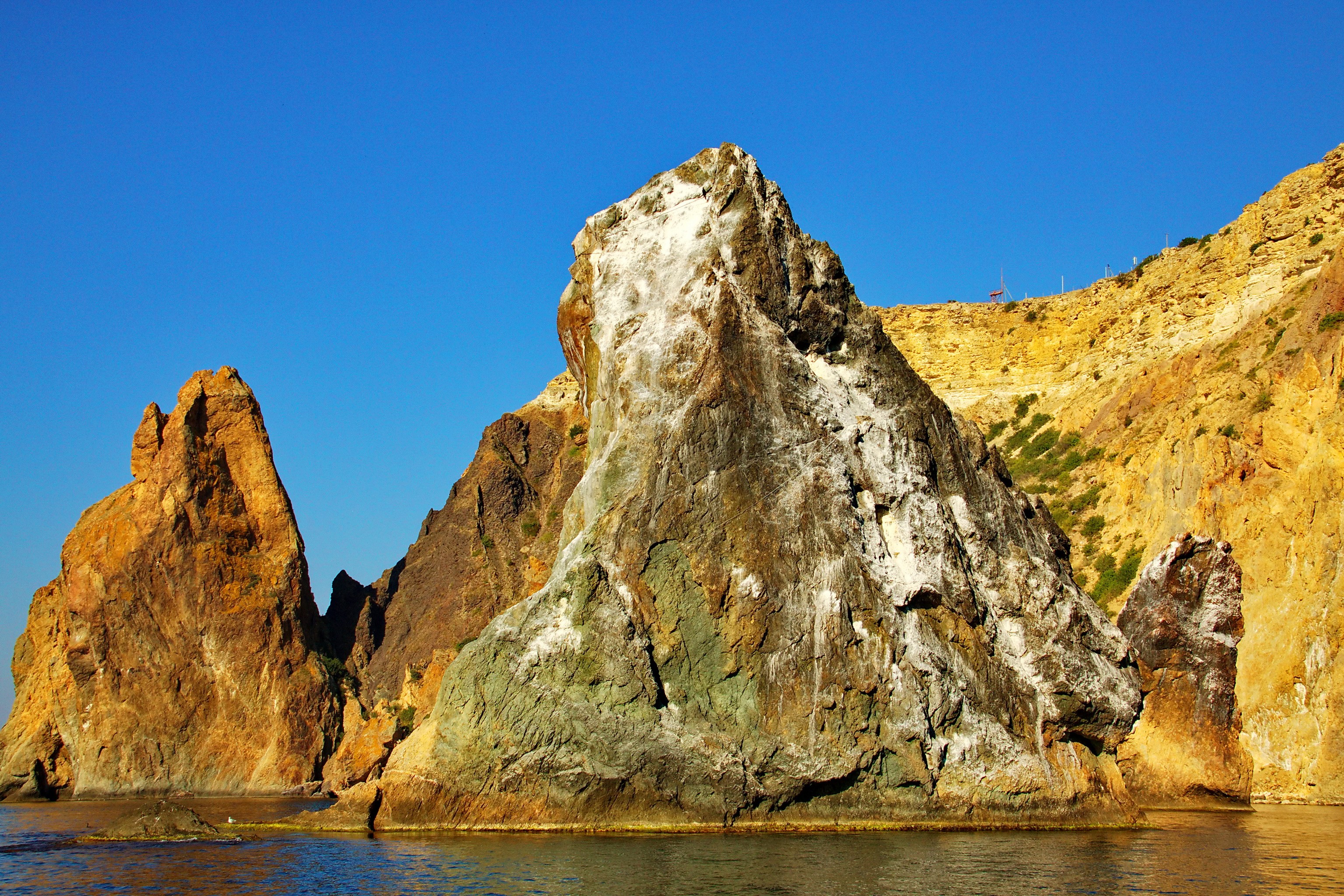 Rocky coast with clear blue sky HD Wallpaper
