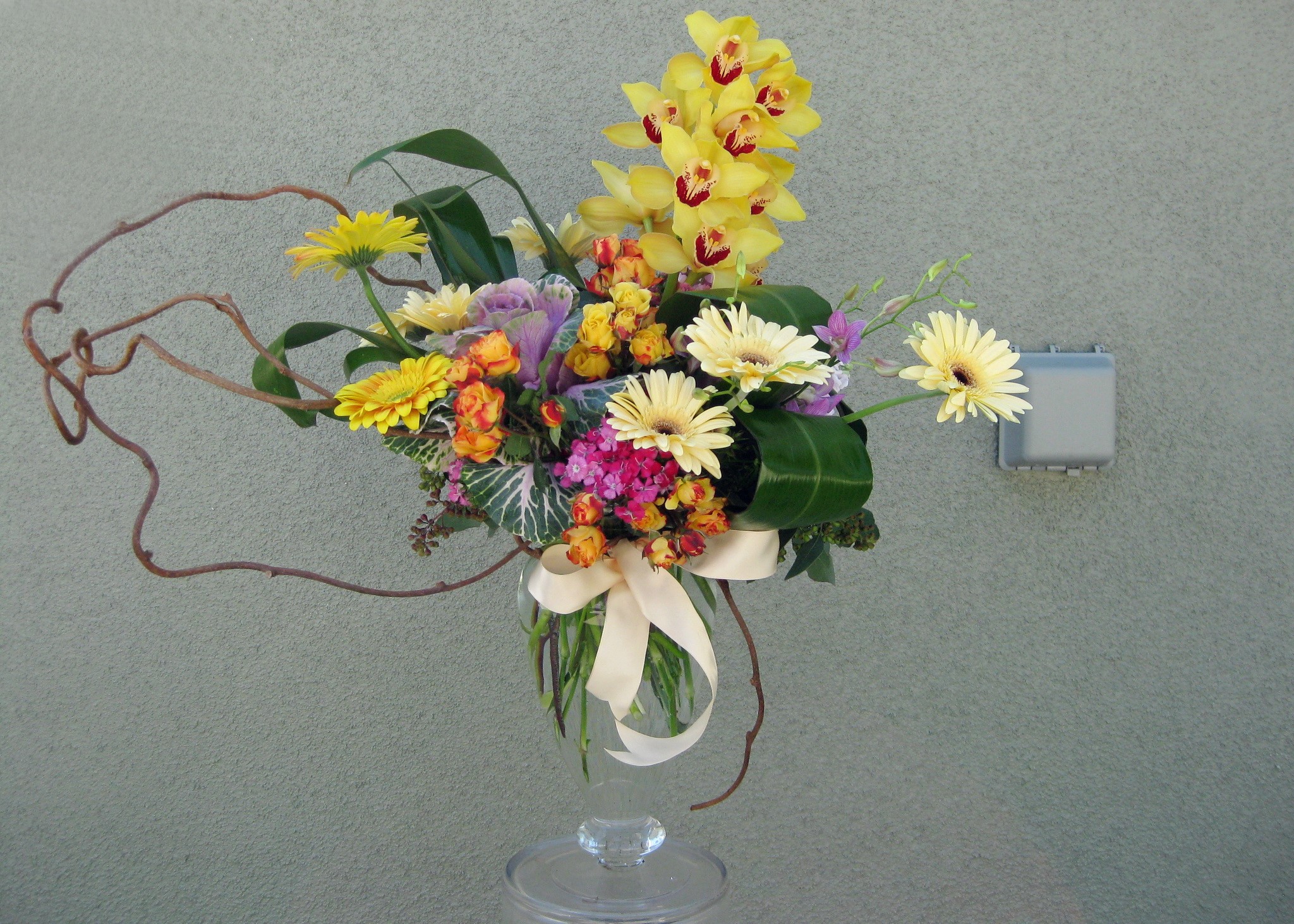 Floral arrangement with yellow orchids and gerbera daisies in a glass vase HD Wallpaper