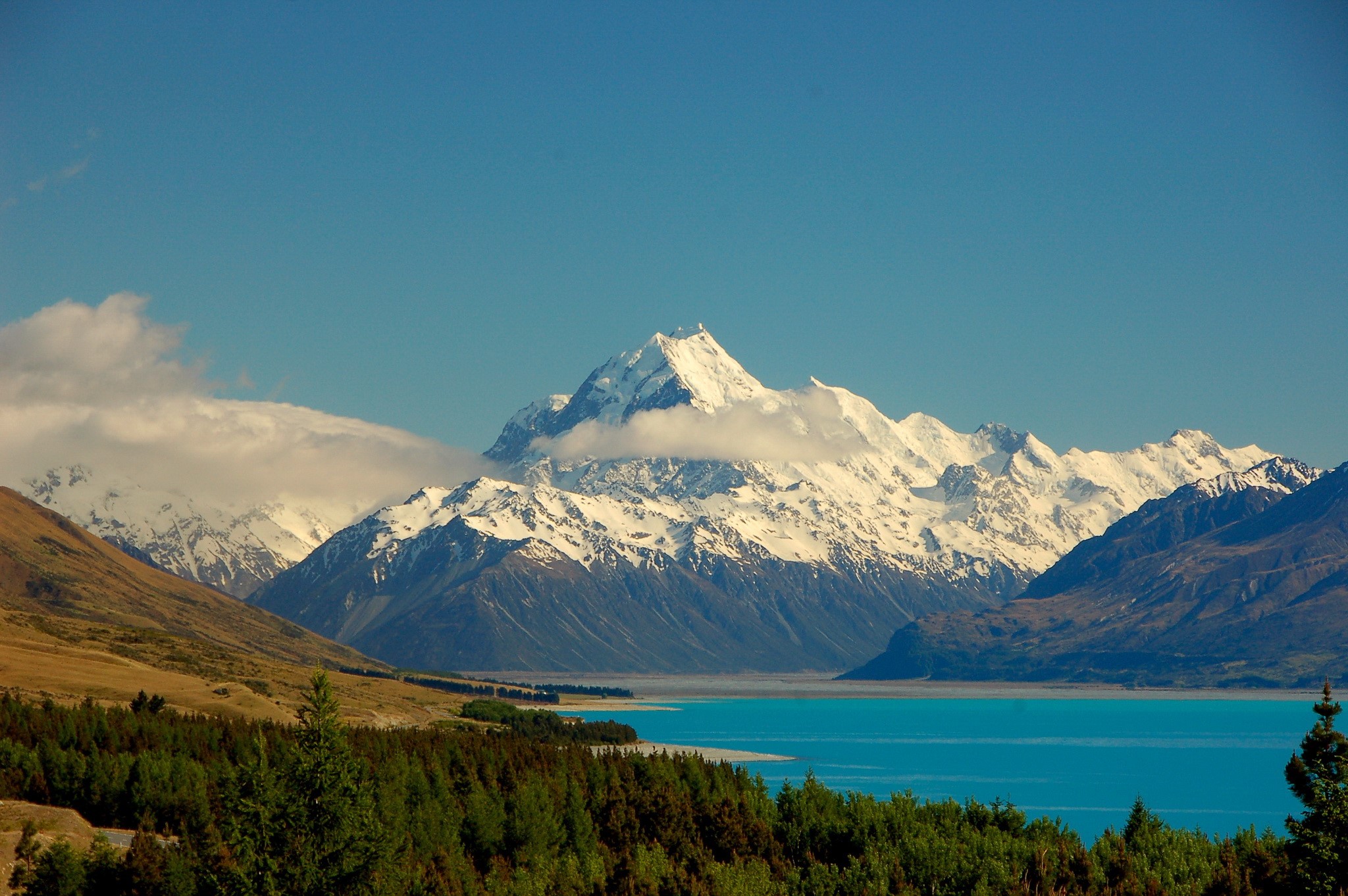 Snow-capped mountains and turquoise lake HD Wallpaper