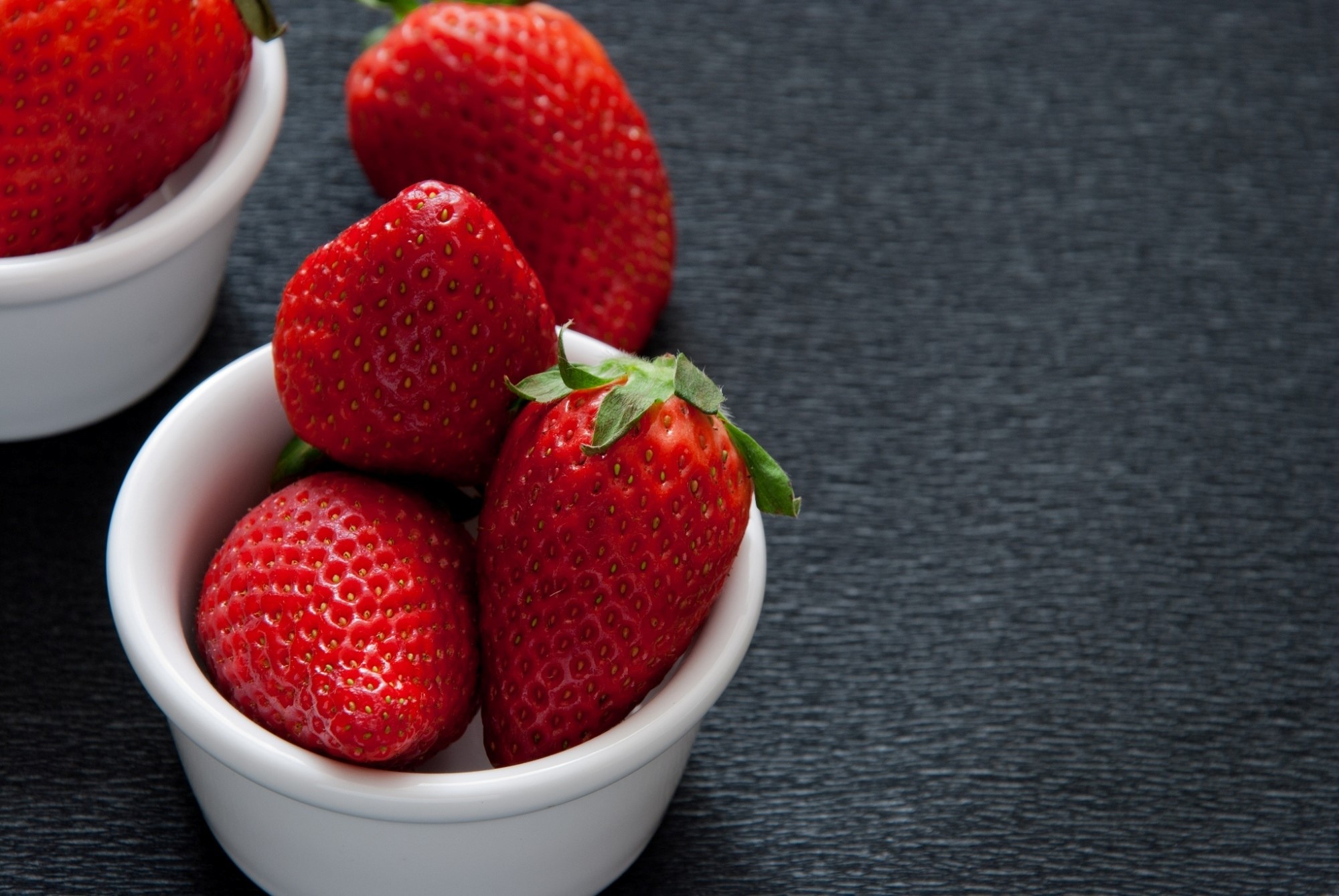 Strawberries in white bowls on a dark surface HD Wallpaper