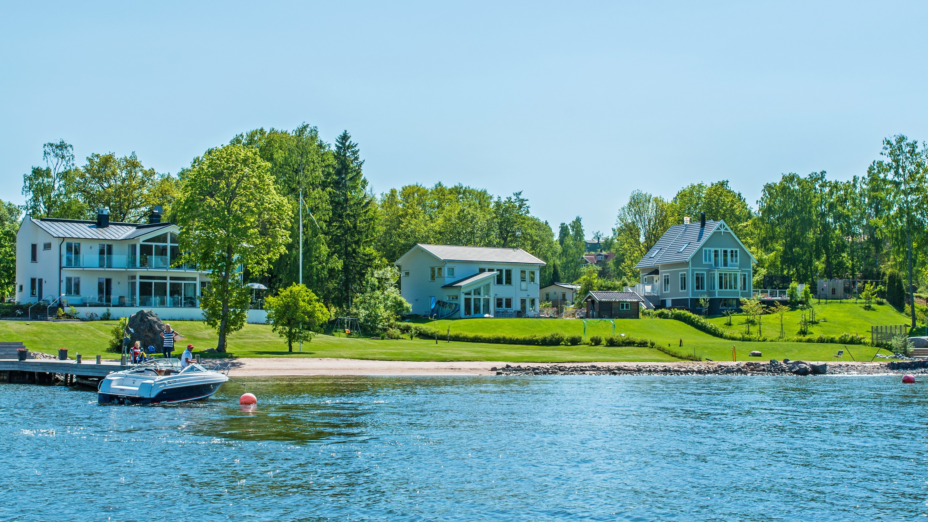 Houses on the shore of a lake in Vaxholm, Sweden HD Wallpaper