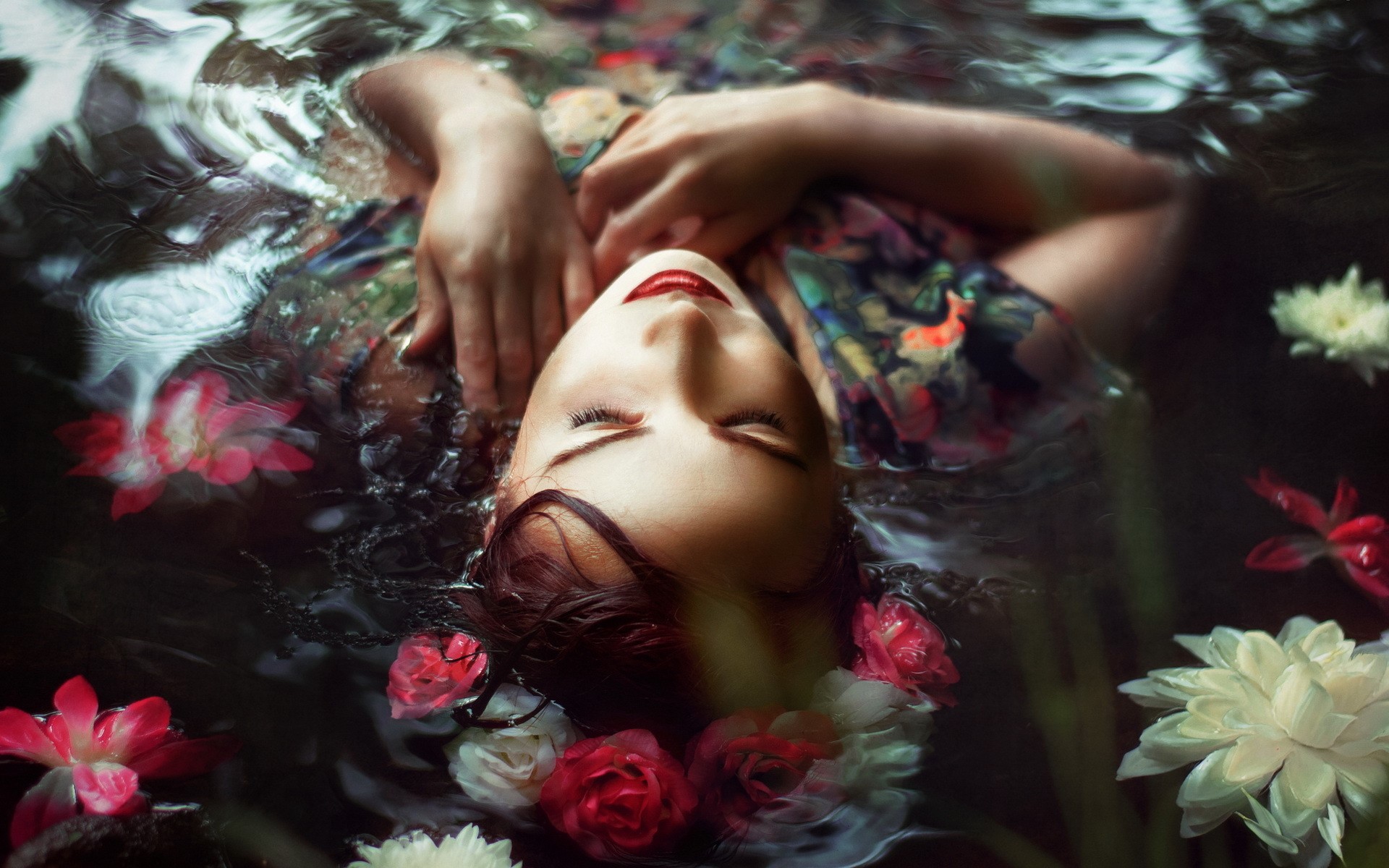 Woman floating in water with flowers HD Wallpaper