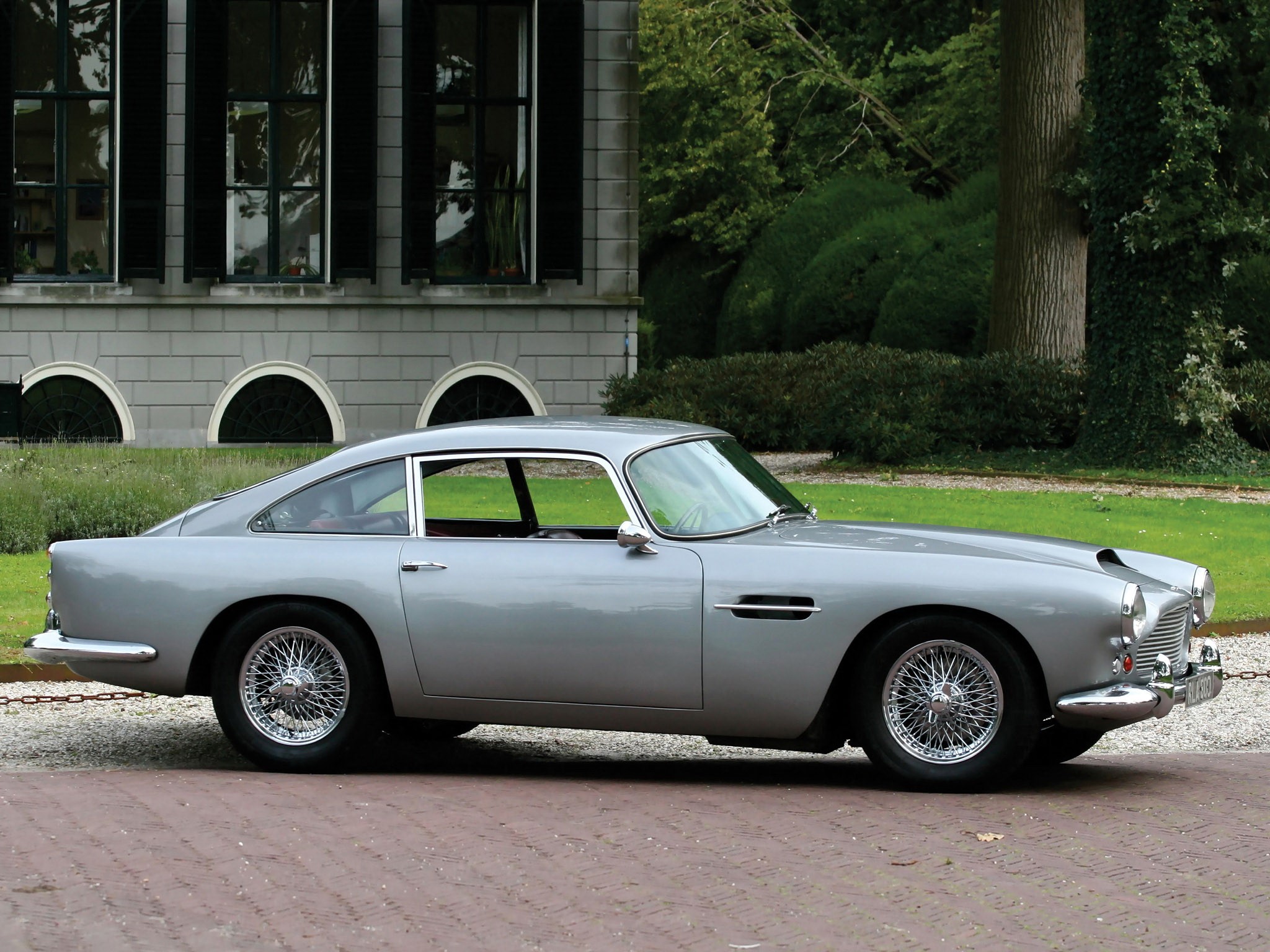 Aston Martin DB4 Series III parked in front of a building HD Wallpaper