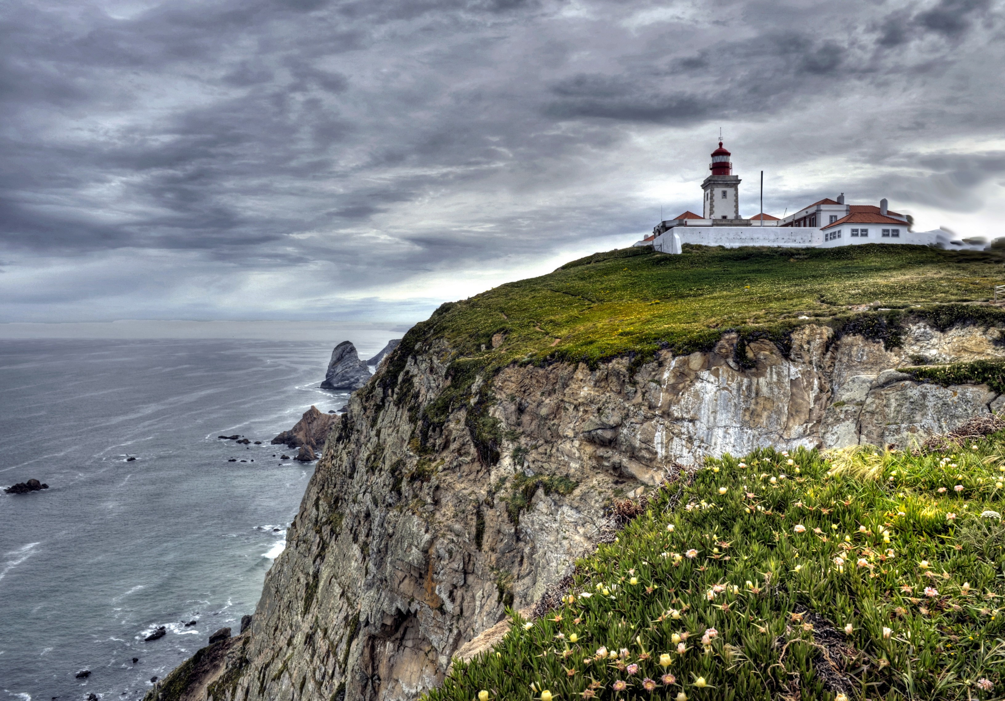 Lighthouse on a cliff overlooking the ocean in Portugal HD Wallpaper