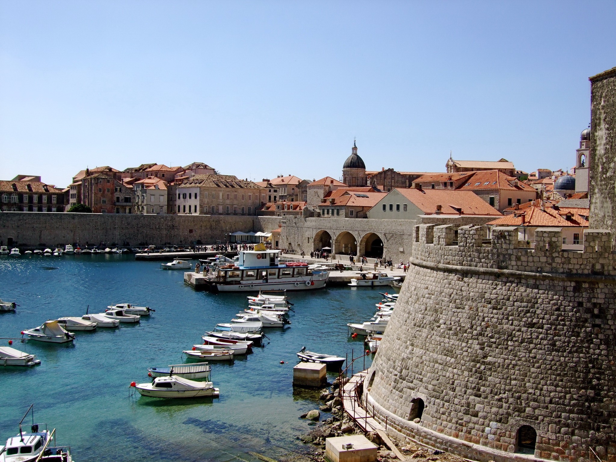 Boats in Dubrovnik harbor with ancient city walls HD Wallpaper