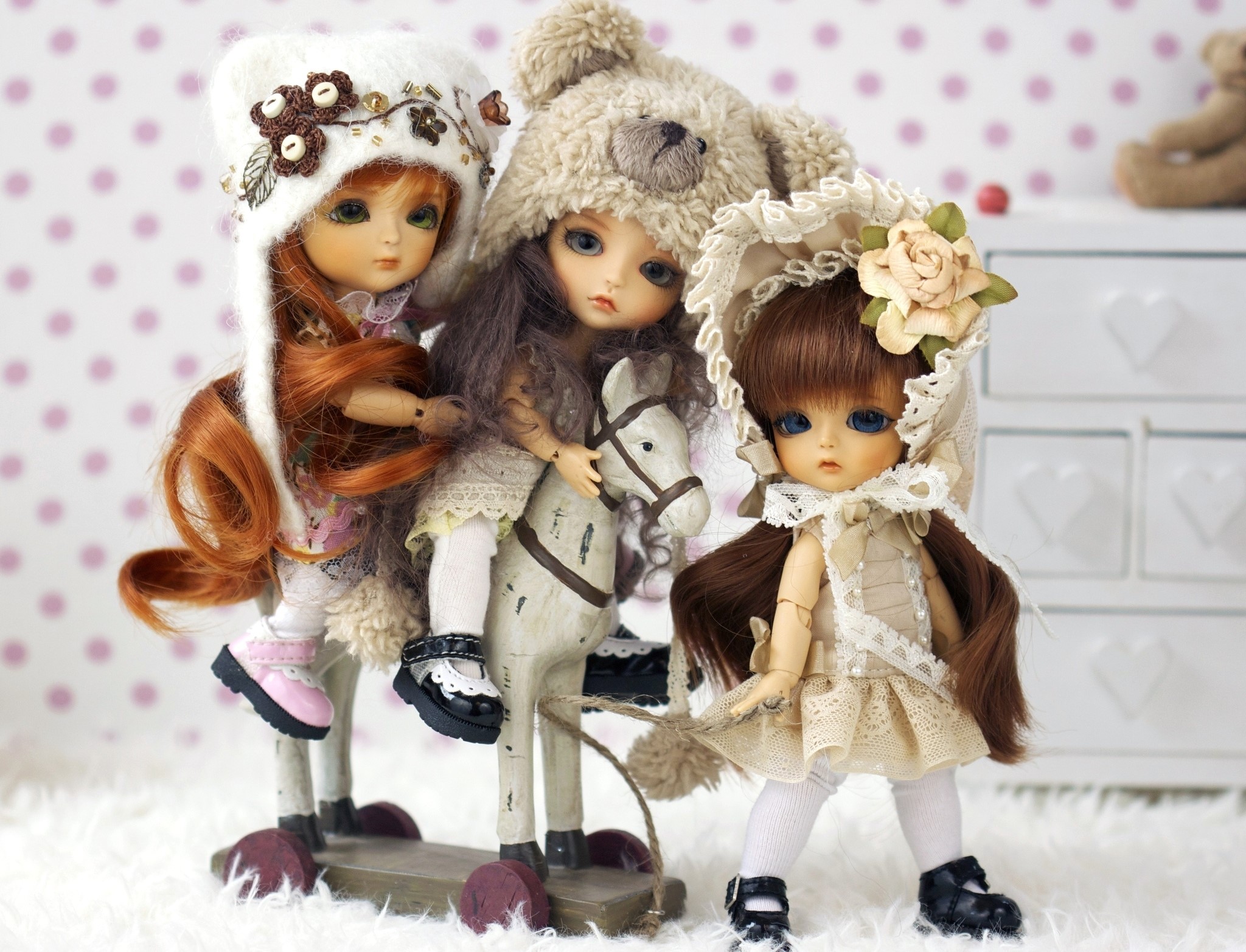 Three dolls dressed in winter outfits on a toy horse HD Wallpaper