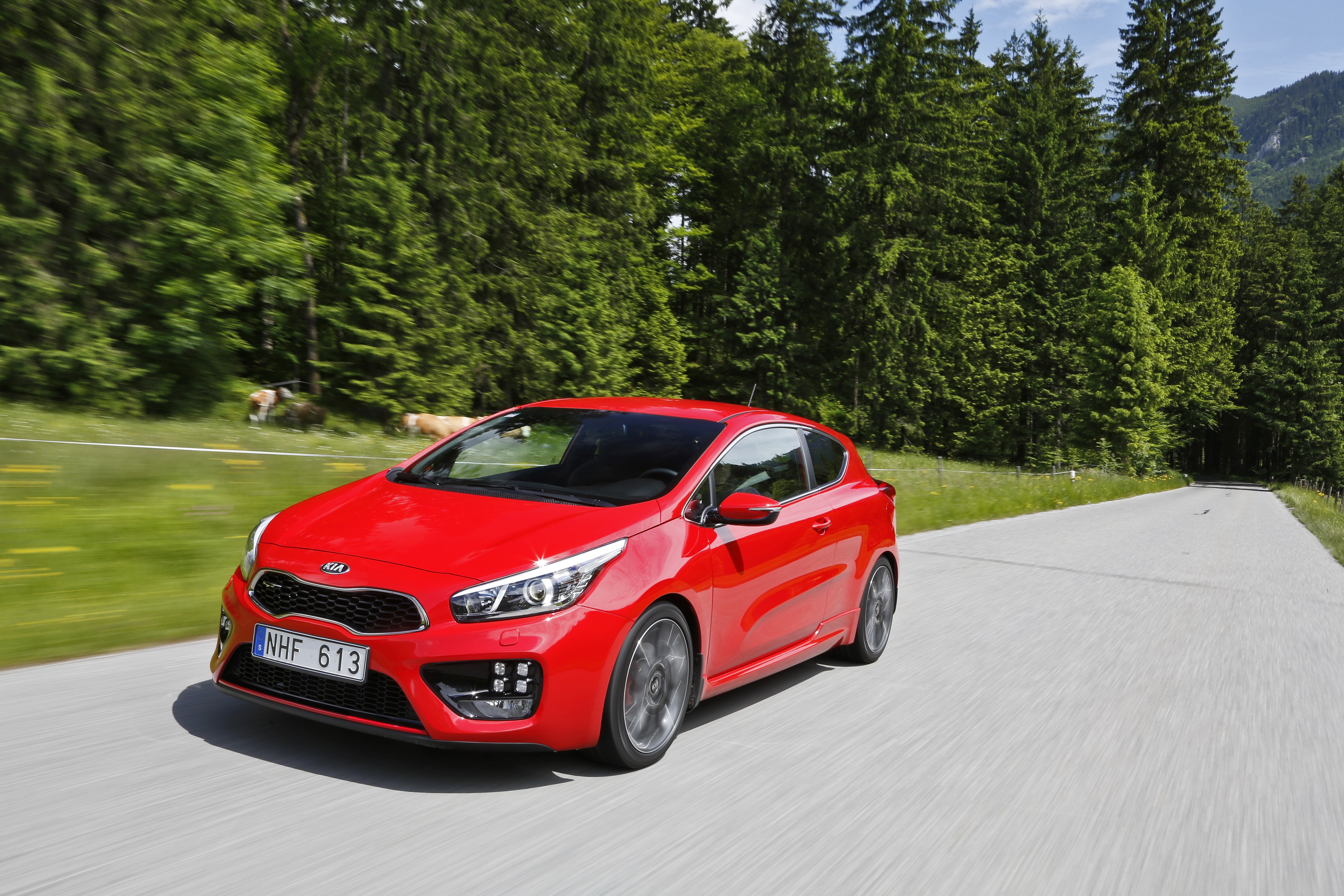 Red 2013 Kia Pro Ceed GT driving on a road HD Wallpaper
