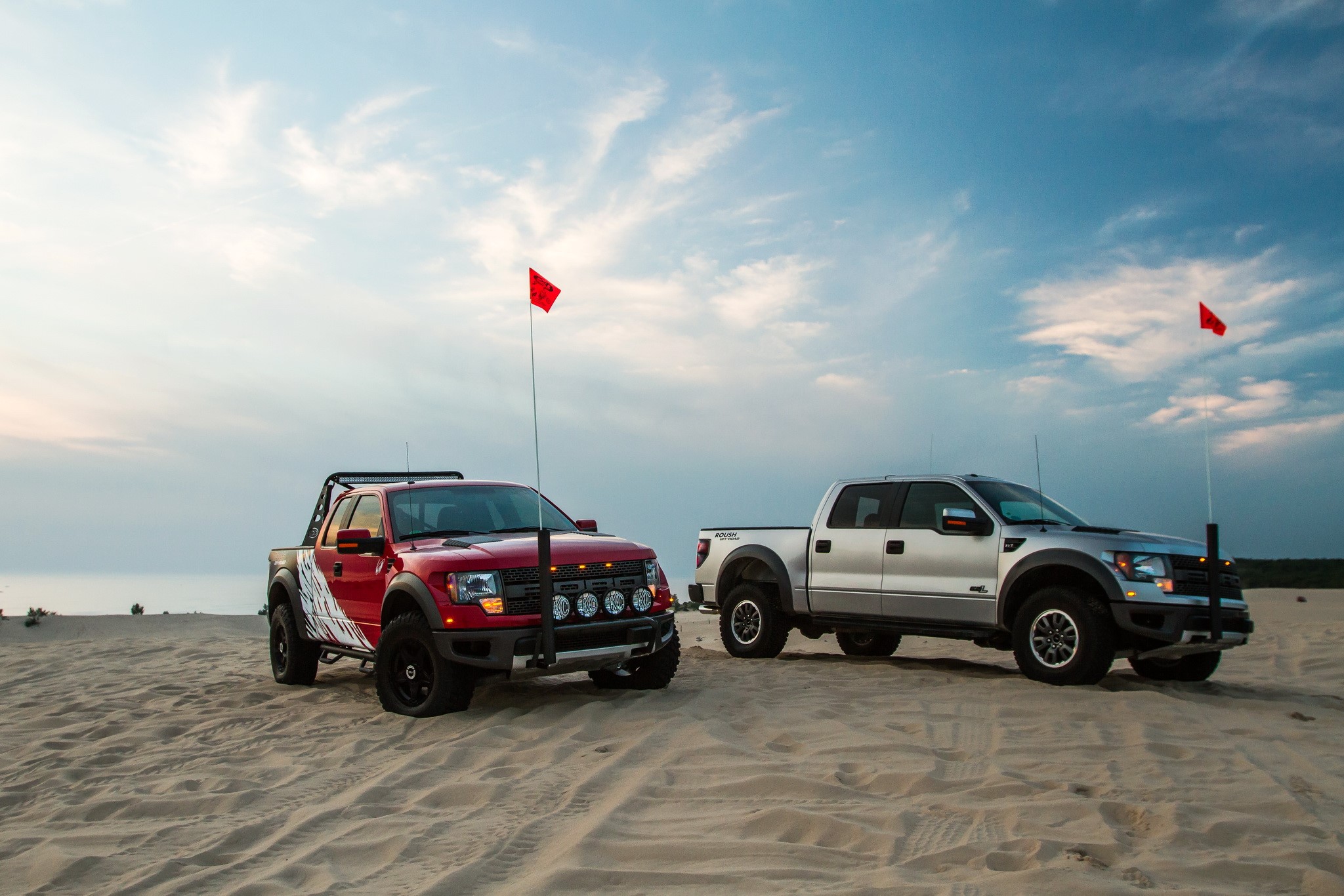 Two Ford F-150 SVT Raptors on sand dunes HD Wallpaper