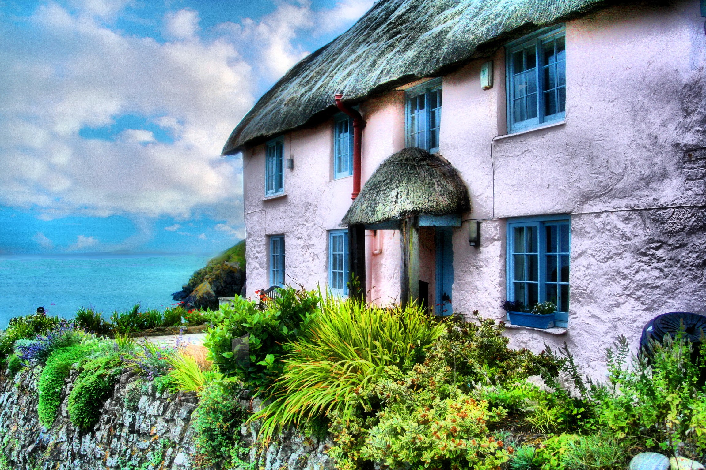 Thatched roof cottage by the sea in Cornwall, England HD Wallpaper