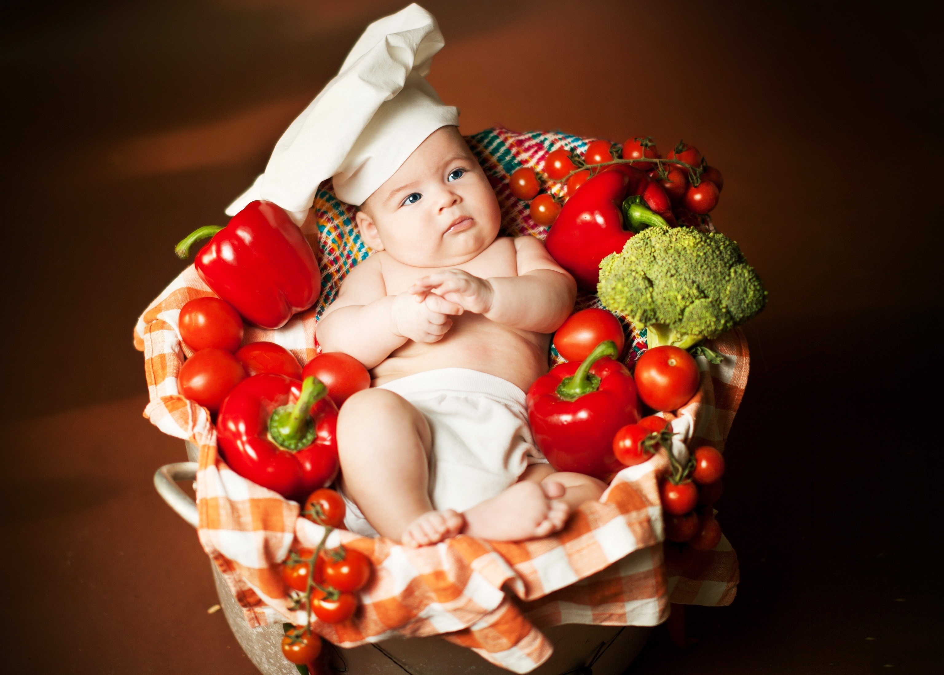Baby in a chef hat surrounded by vegetables HD Wallpaper