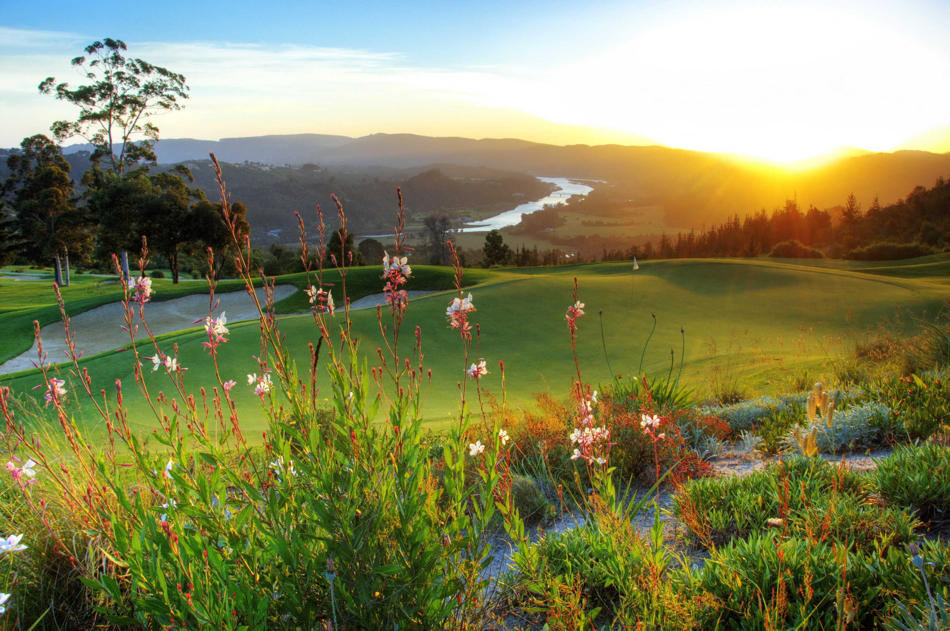 Golf course with river and mountains at sunset HD Wallpaper