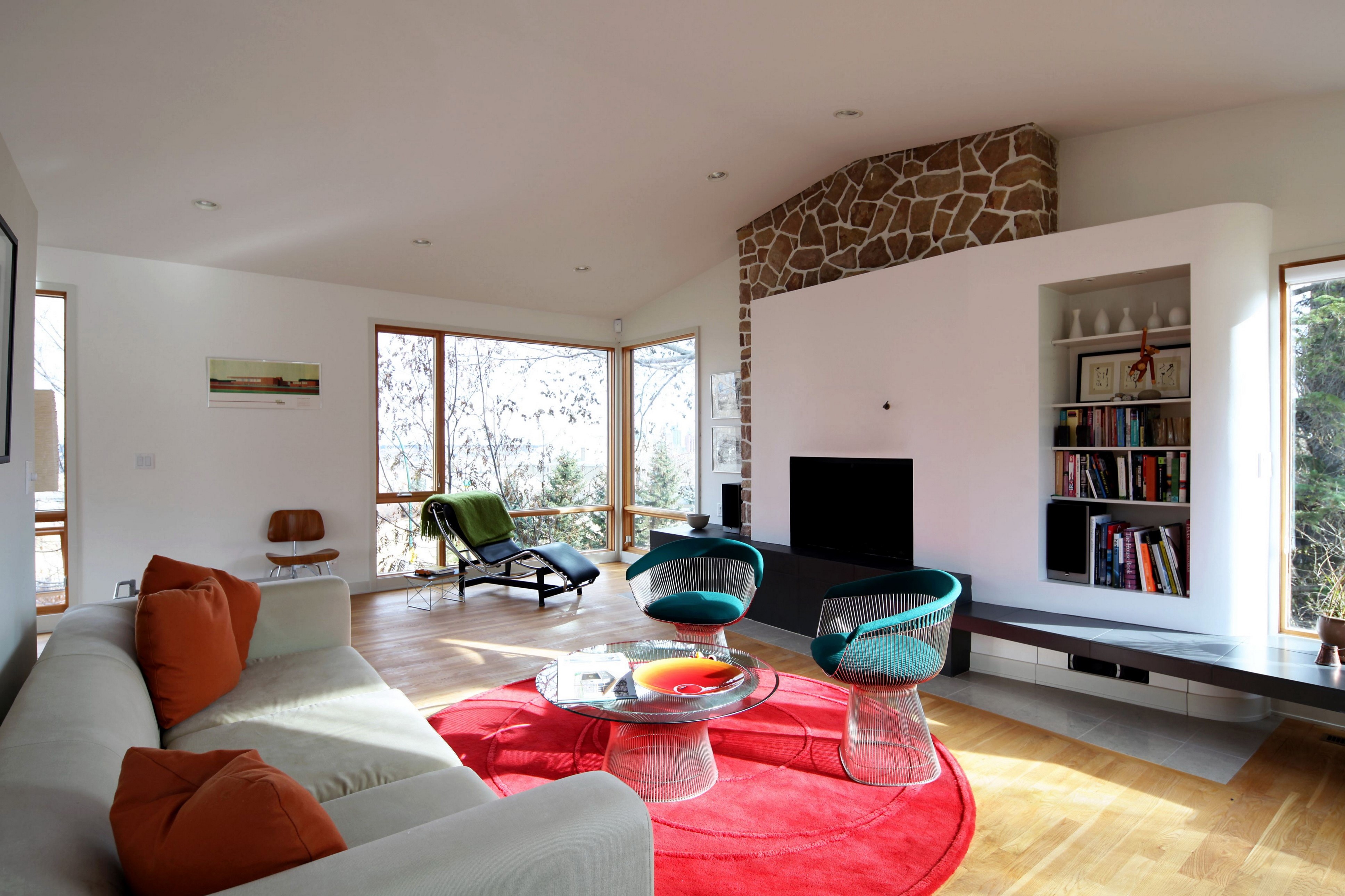 Modern living room with stone fireplace and large windows HD Wallpaper
