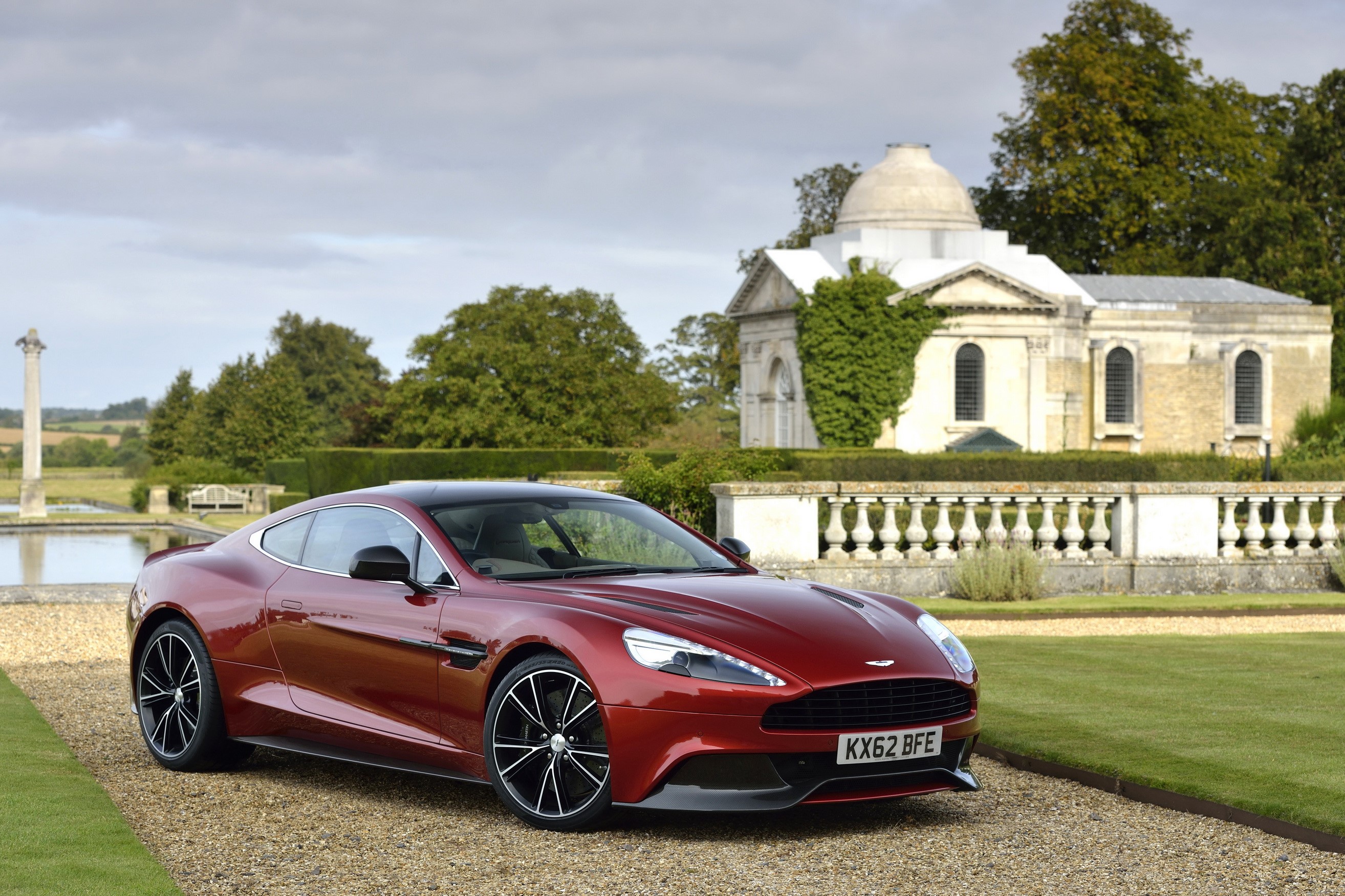 Red Aston Martin Vanquish parked in front of a building HD Wallpaper