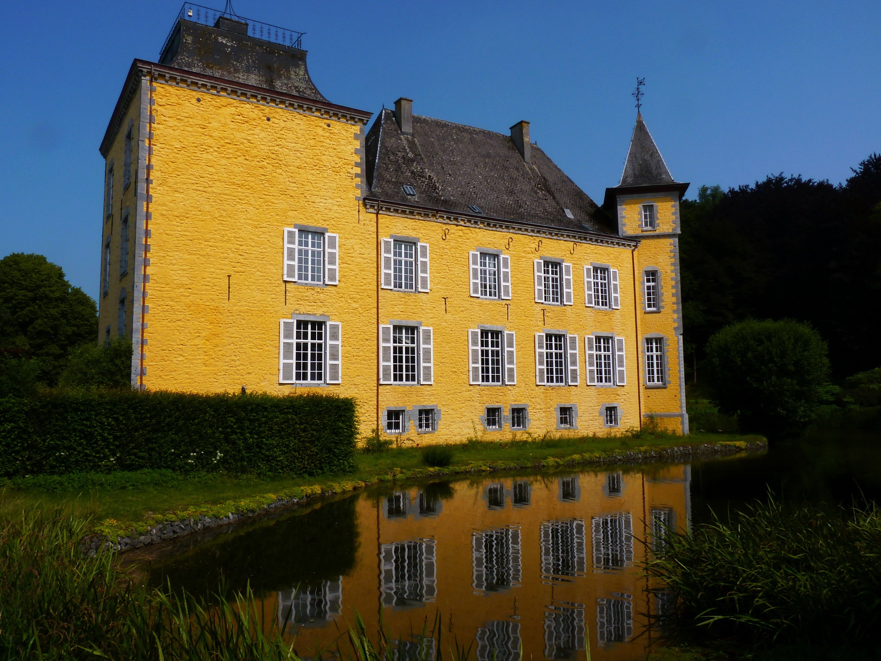 Yellow castle in Belgium reflected in water HD Wallpaper