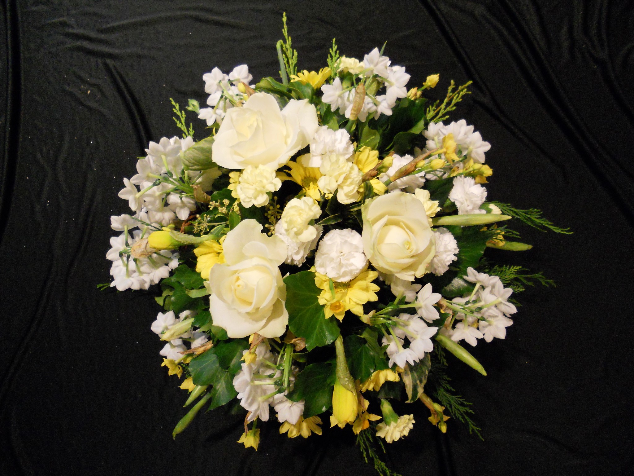 White and yellow floral arrangement on black fabric HD Wallpaper