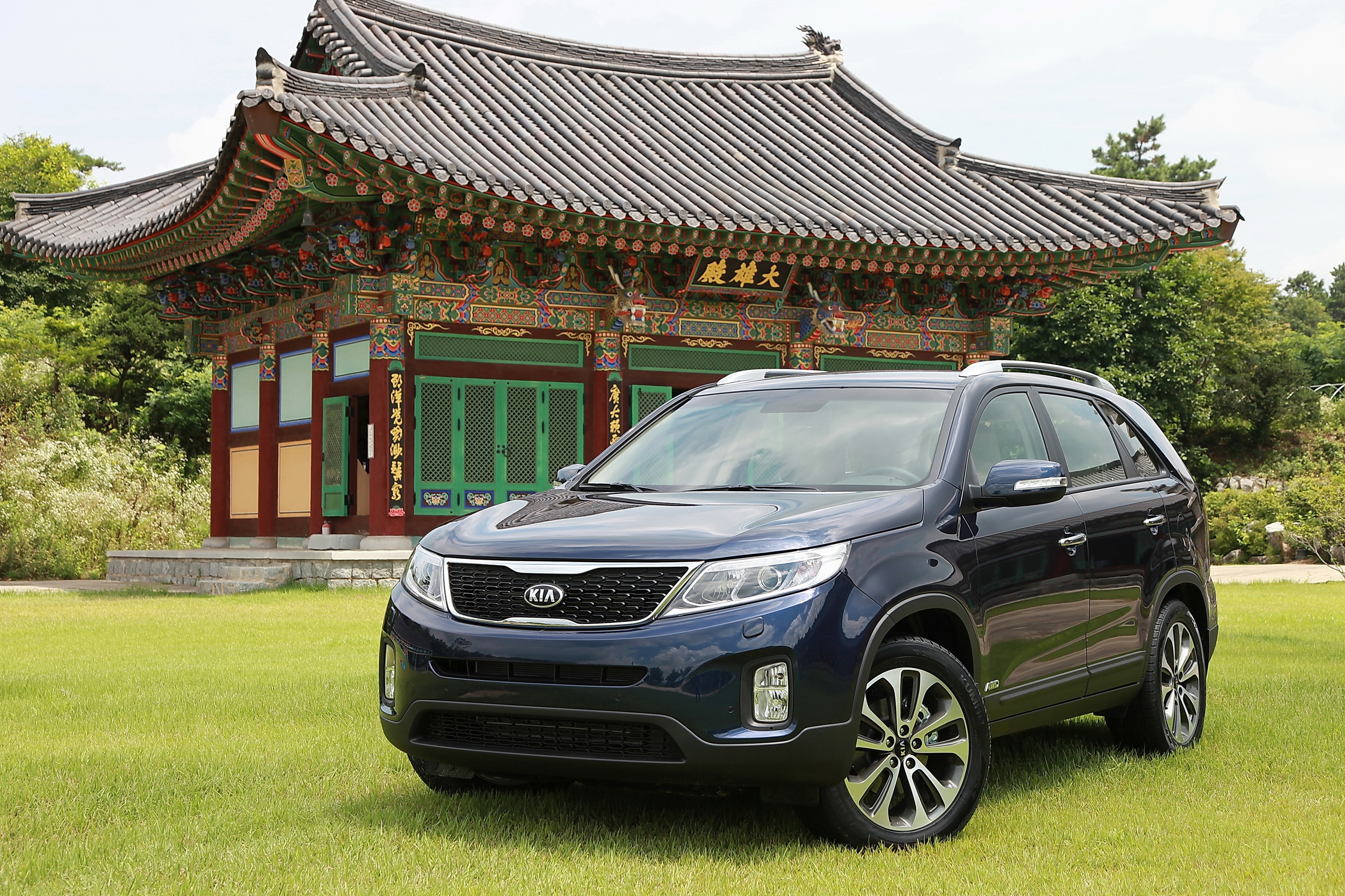 Dark Blue 2014 Kia Sorento parked on grass in front of a pagoda HD Wallpaper