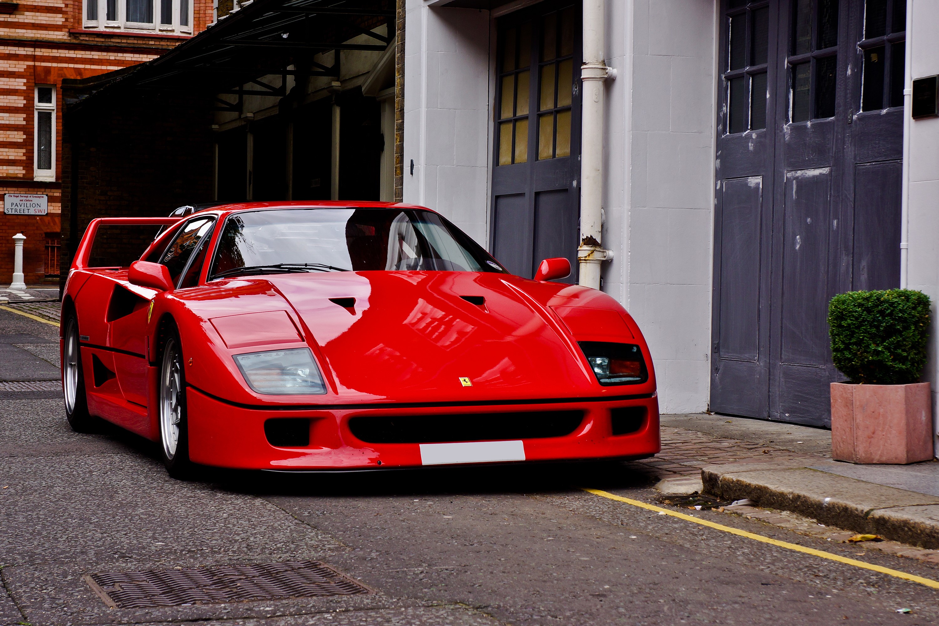 Red Ferrari F40 parked on a street HD Wallpaper