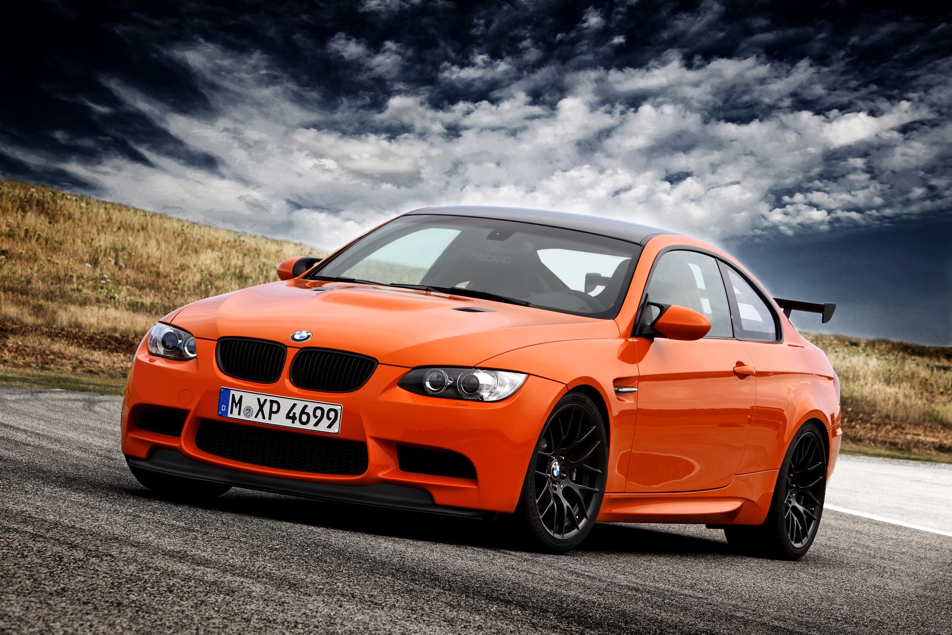 Orange BMW M3 Coupe on a Racetrack HD Wallpaper