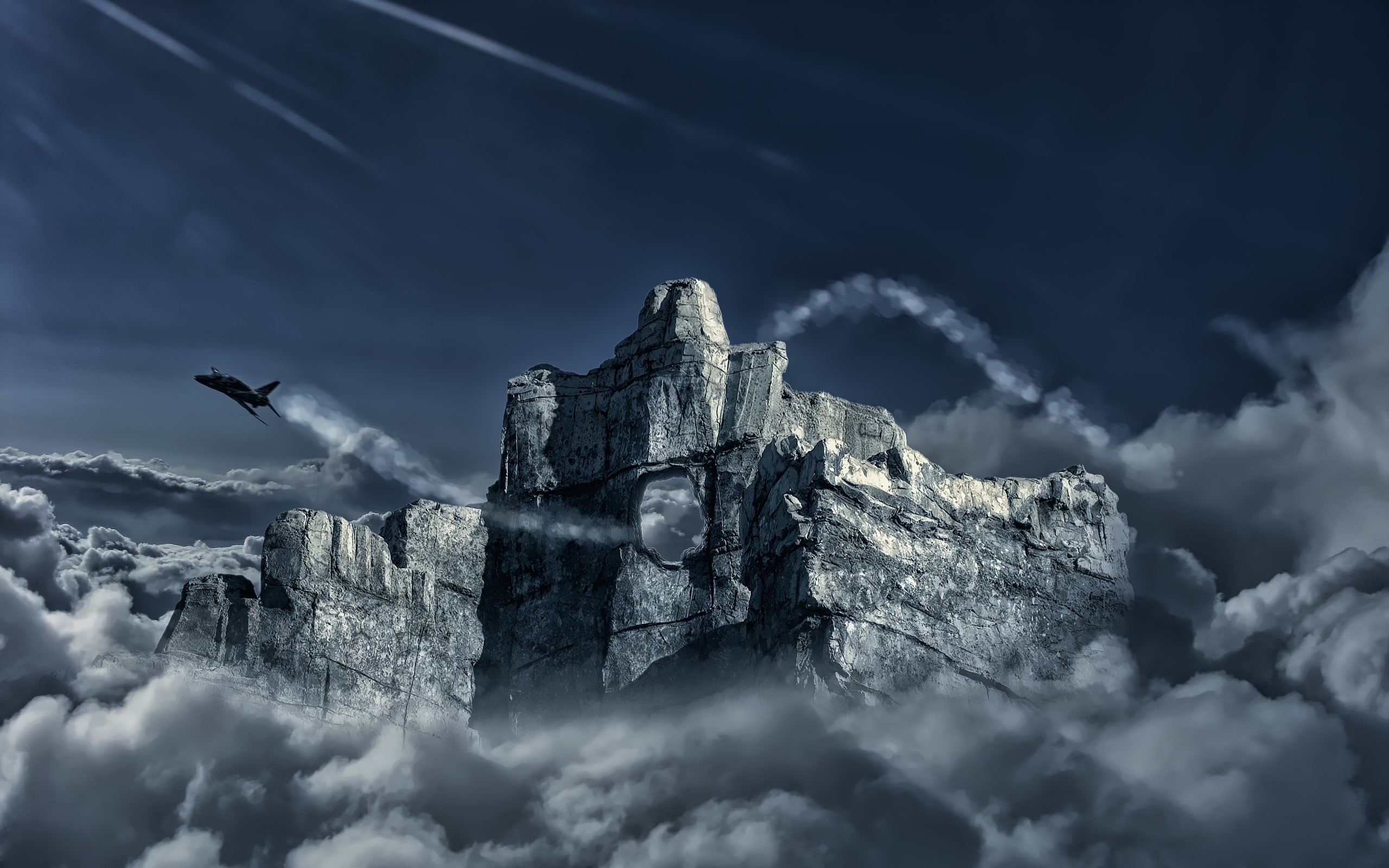 Fighter jet flies near a rocky mountain peak above clouds HD Wallpaper