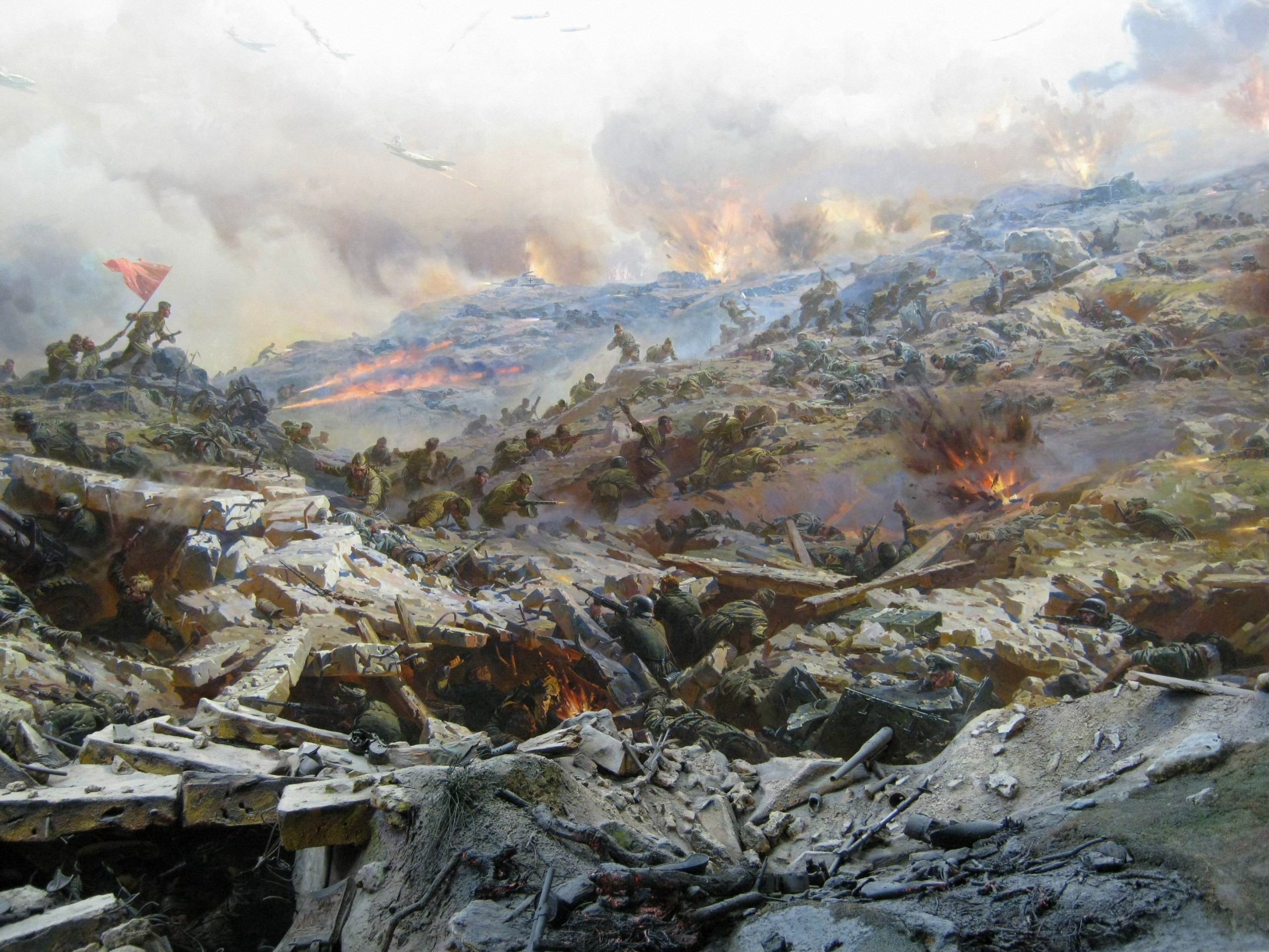 Soldiers in a chaotic battle scene with explosions and aircraft HD Wallpaper