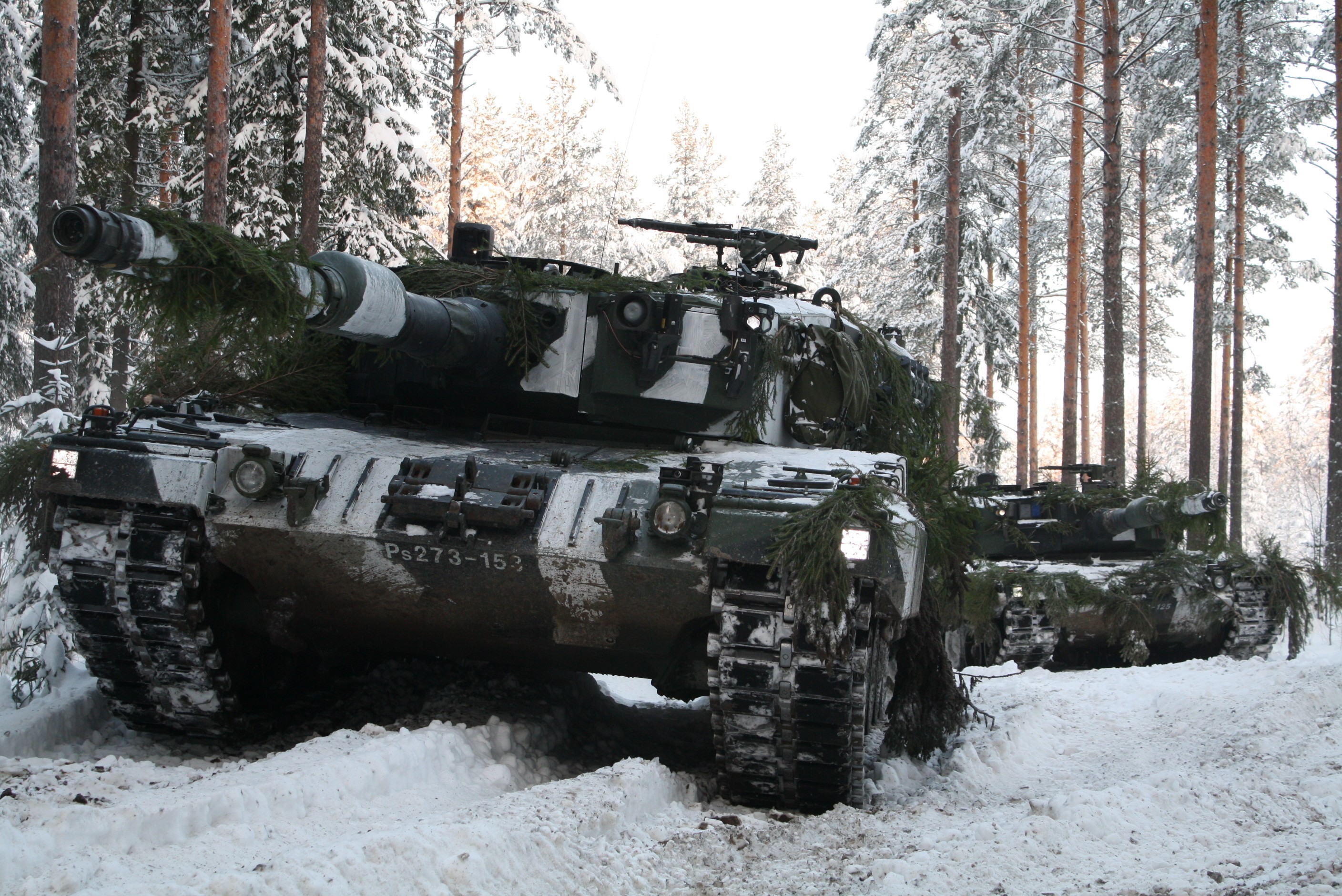 Leopard tanks in a snowy forest HD Wallpaper