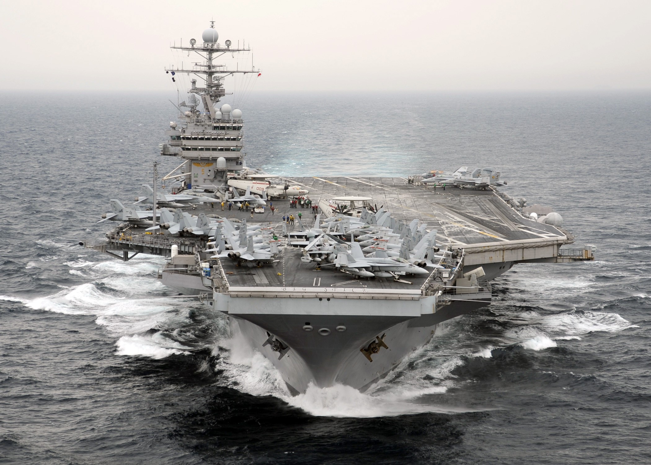 Aircraft carrier with fighter jets on deck at sea HD Wallpaper