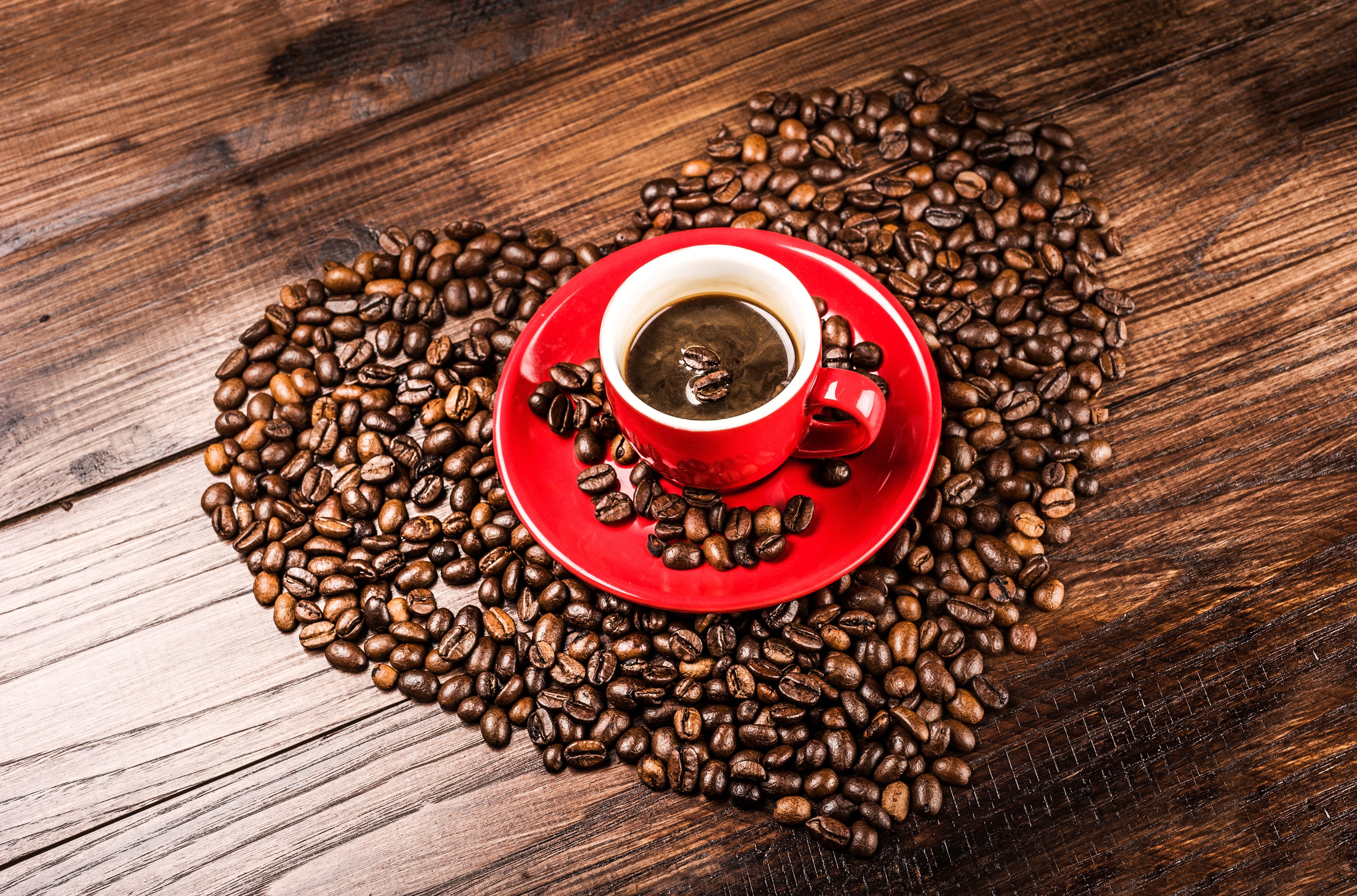 Coffee beans in a heart shape with a cup of coffee HD Wallpaper