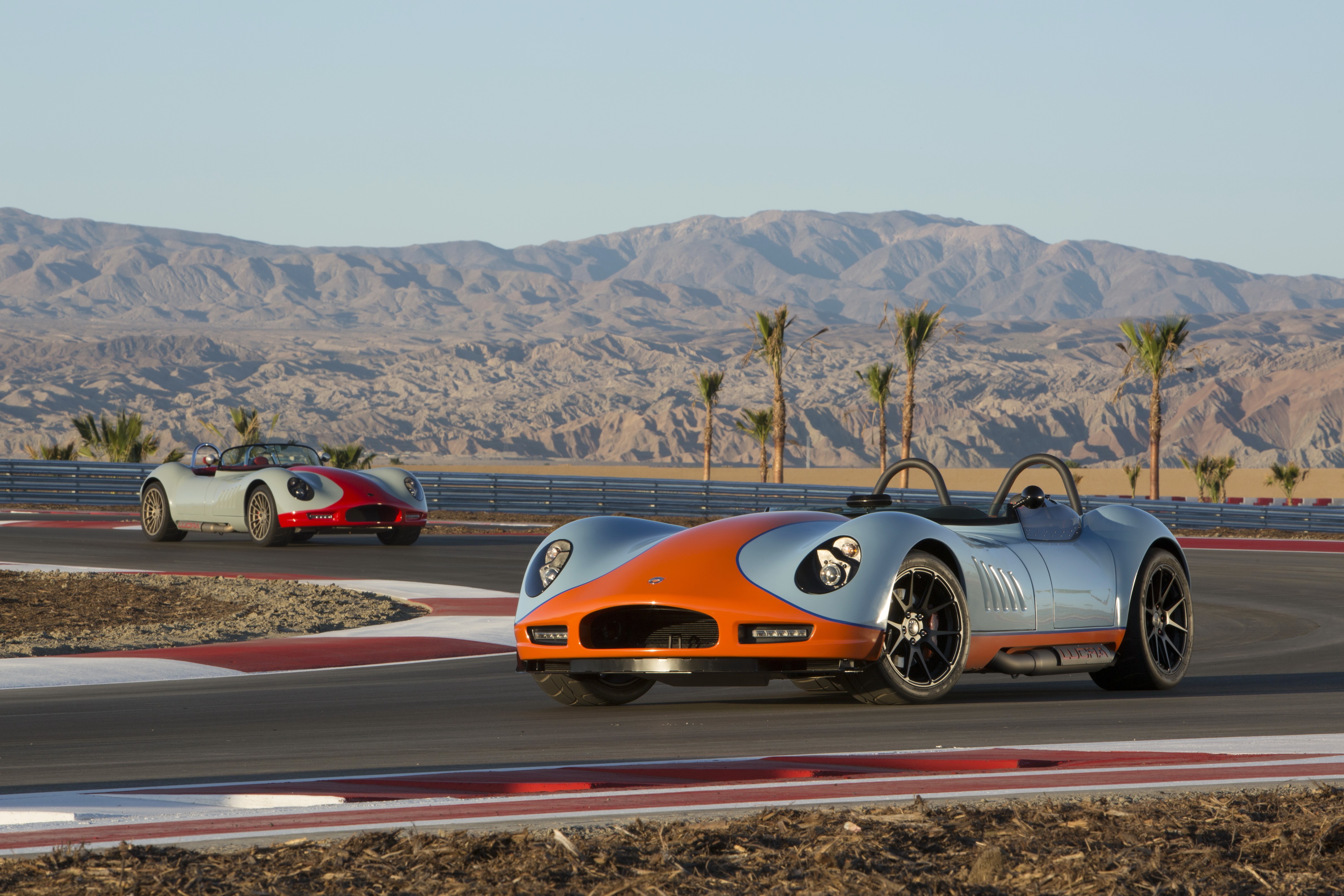 Two 2012 Lucra LC470 sports cars on a race track HD Wallpaper
