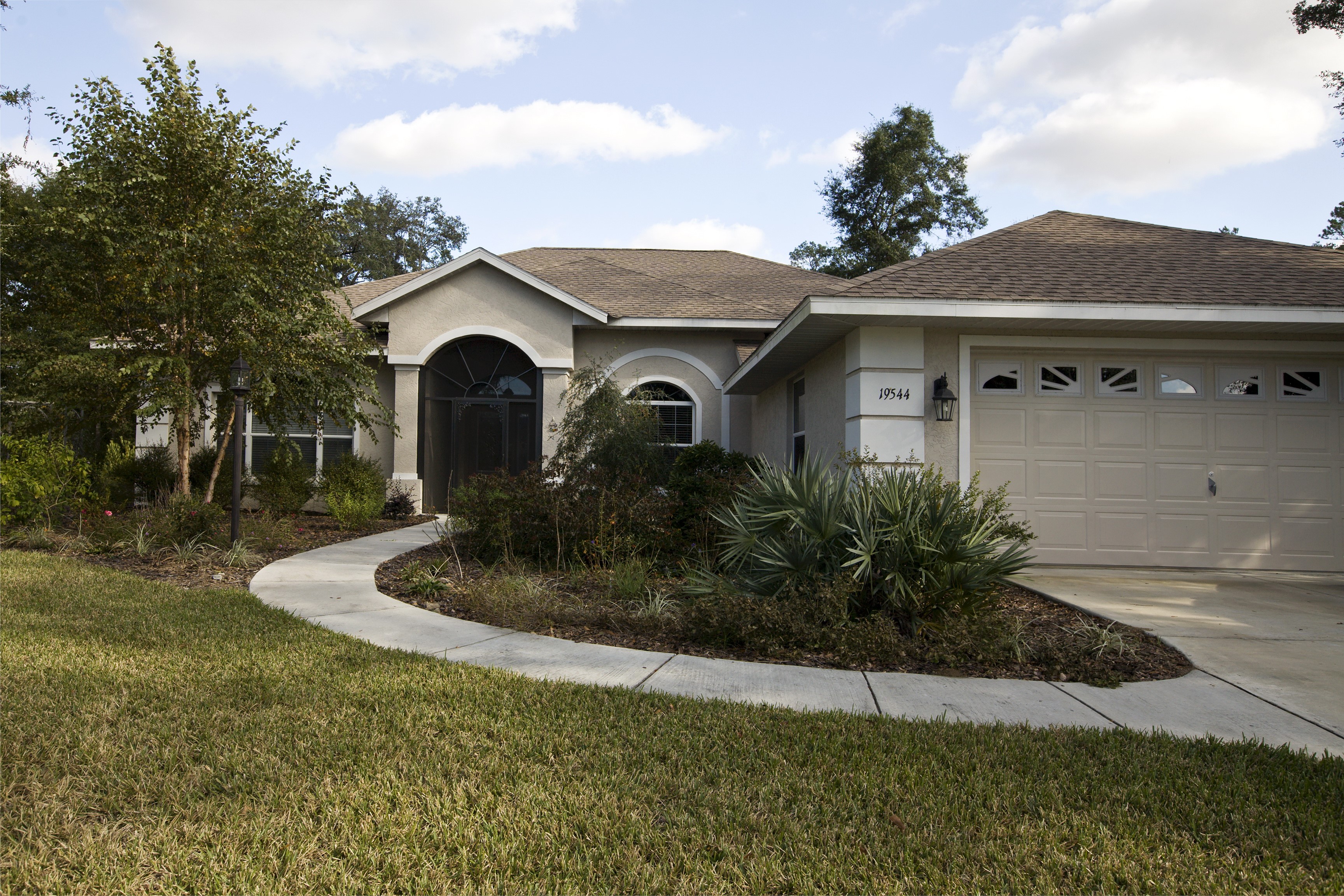 Single-story house with a garage and curved walkway HD Wallpaper