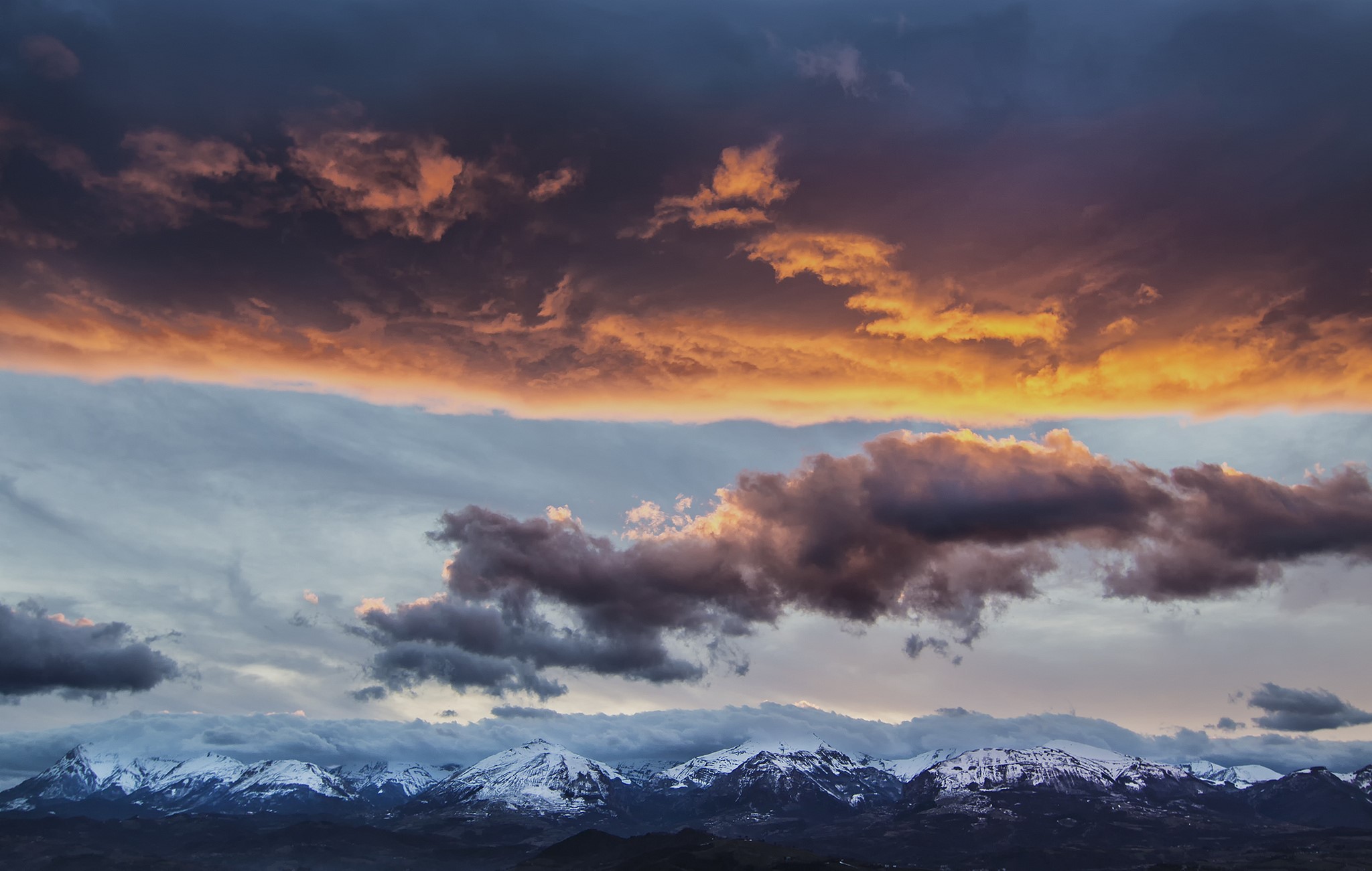 Dramatic sunset clouds over snow-capped Apennine Mountains in Italy HD Wallpaper