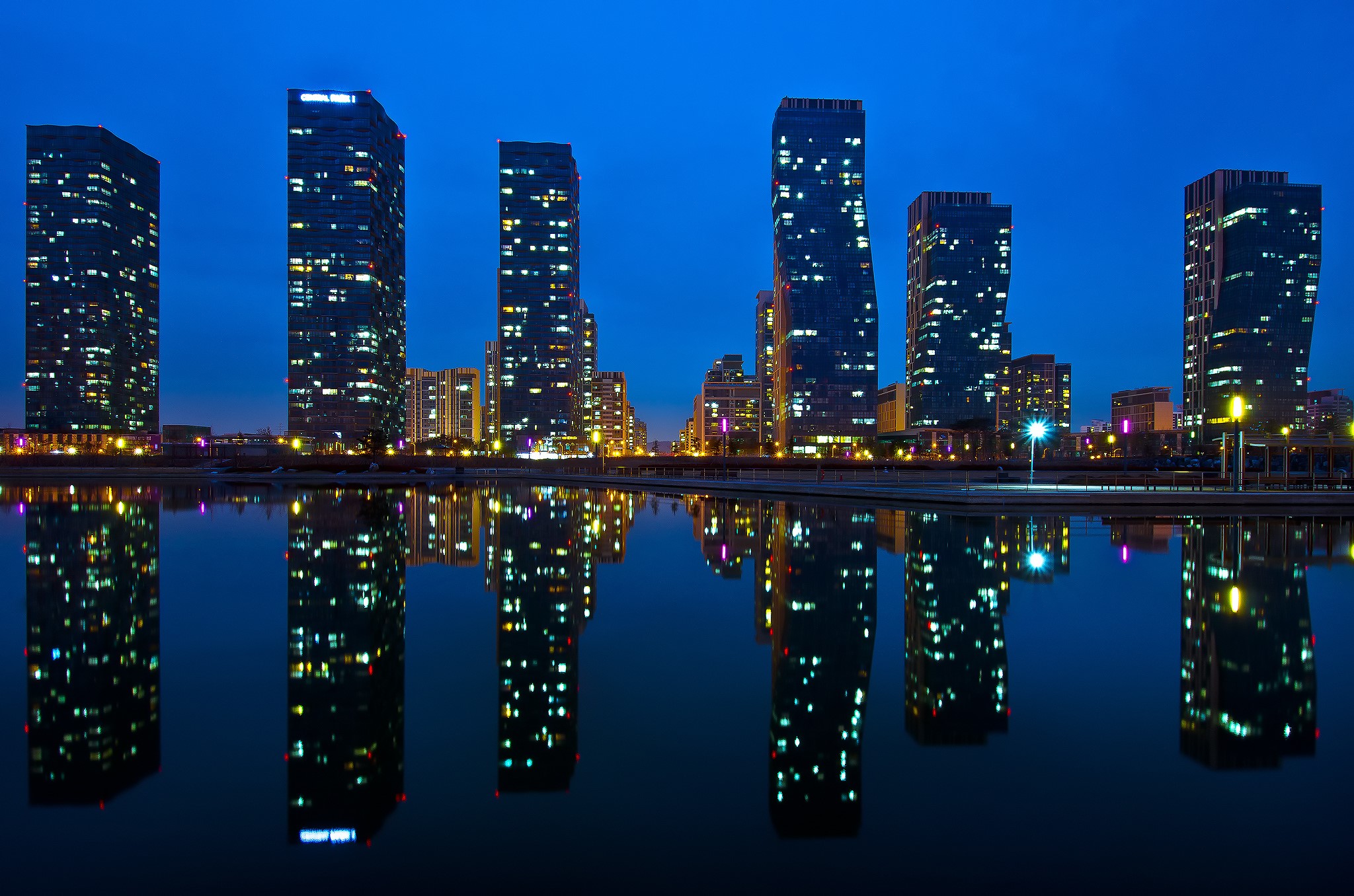 Skyscrapers reflecting in water at night in Incheon New Songdo City HD Wallpaper