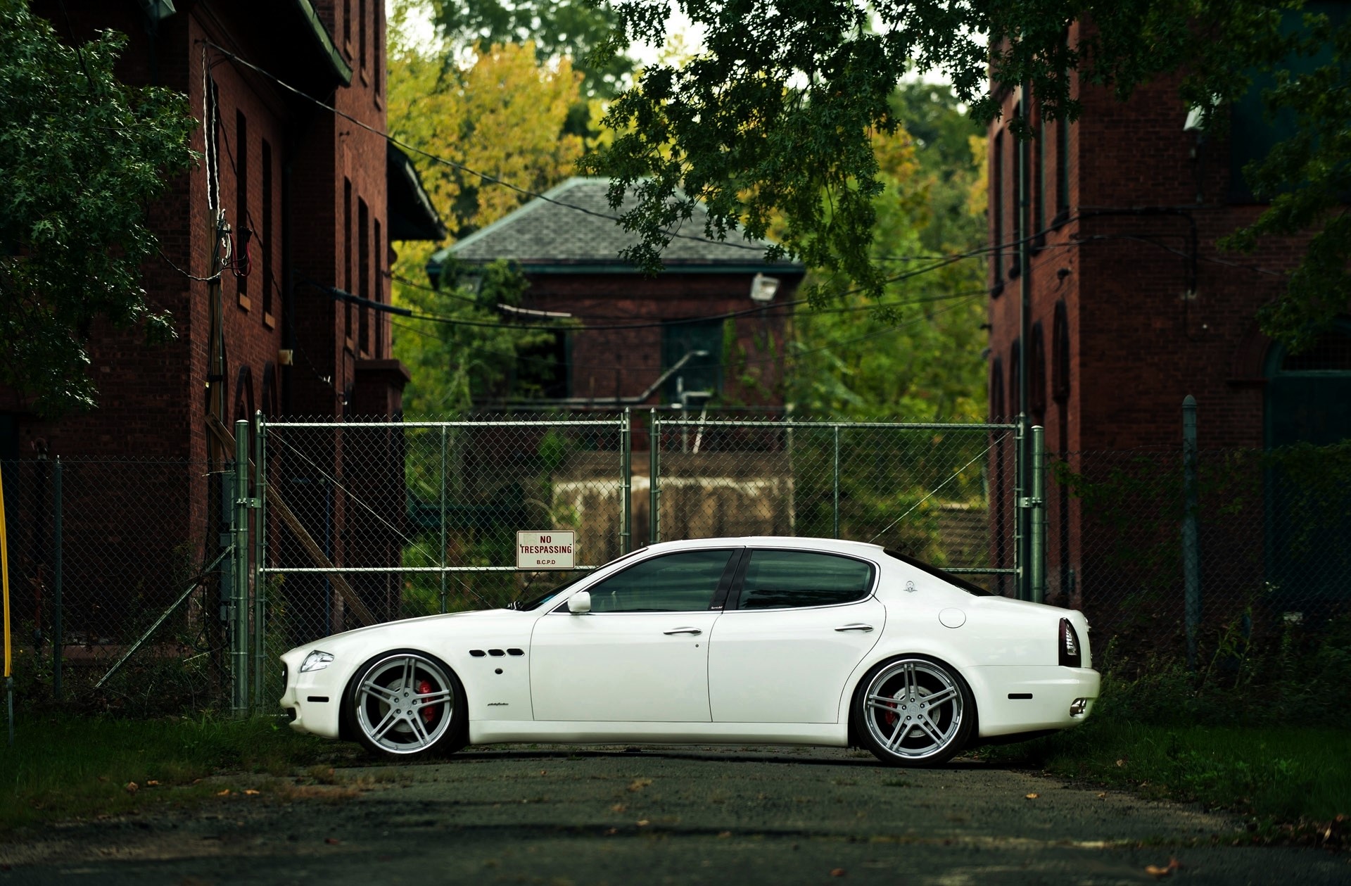 White Maserati Quattroporte parked by abandoned buildings HD Wallpaper