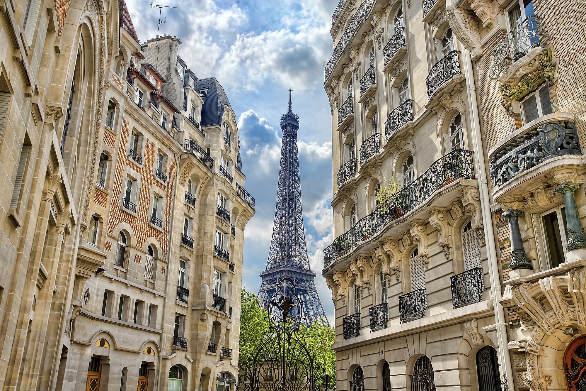 Eiffel Tower viewed between Parisian buildings HD Wallpaper